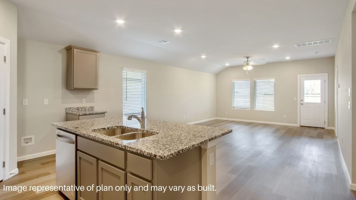 Bright and spacious kitchen with quartz countertops, stainless steel appliances, and an island with bar seating.