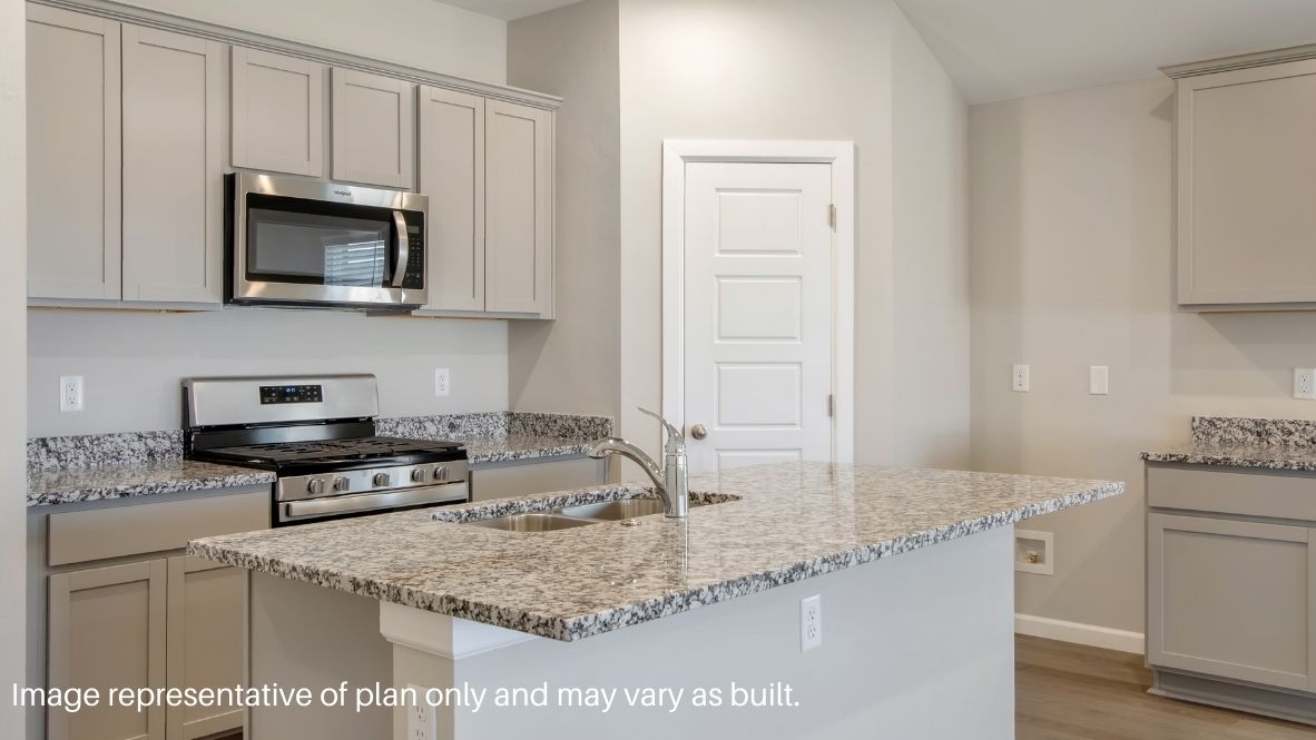 Bright and spacious kitchen with quartz countertops, stainless steel appliances, and an island with bar seating.