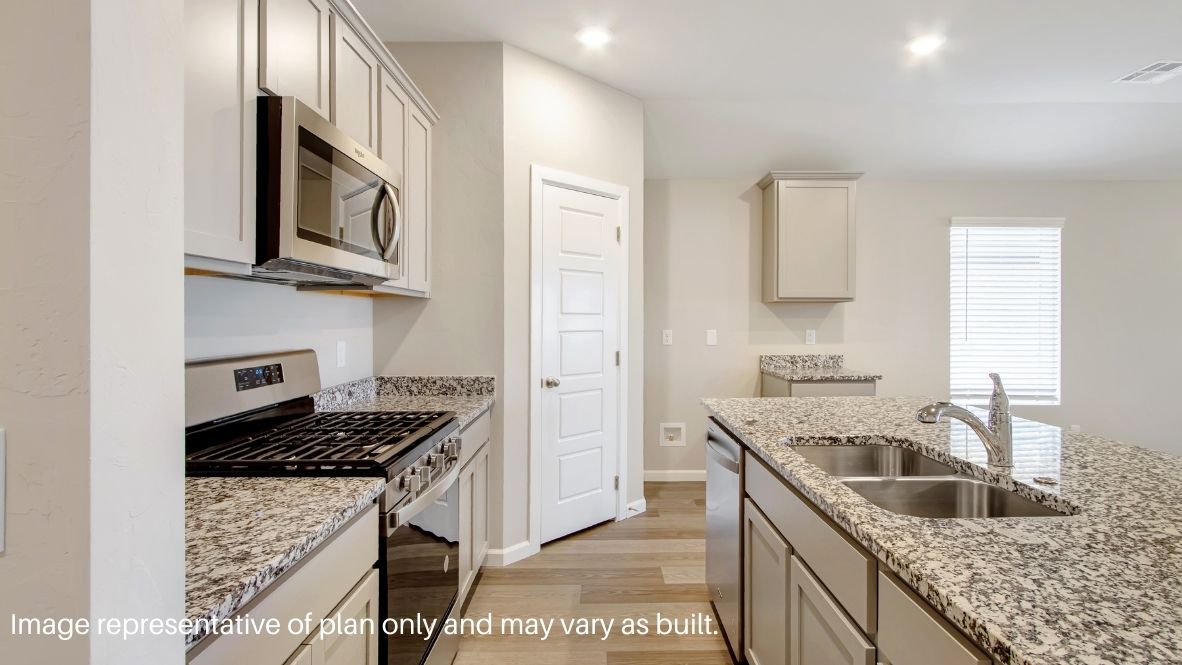 Bright and spacious kitchen with quartz countertops, stainless steel appliances, and an island with bar seating.
