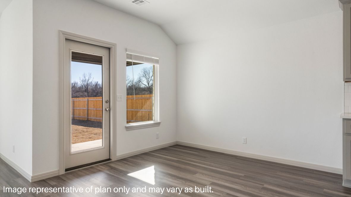 Formal dining room with large windows, vinyl wood floors, and view of the backyard.