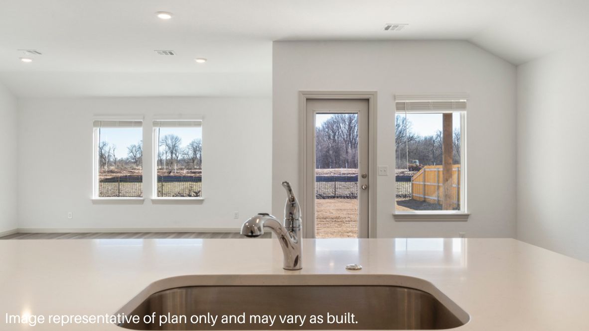 Bright and spacious kitchen with quartz countertops, stainless steel appliances, and an island with bar seating.