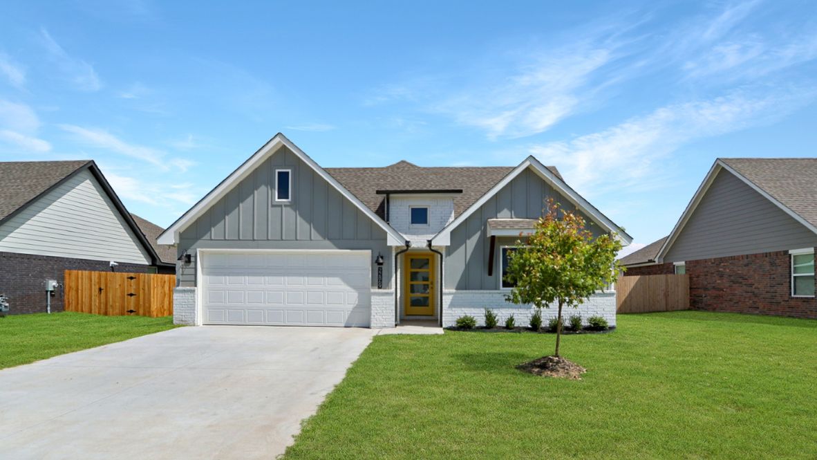 Modern single-story home with a brick exterior, two-car garage, and well-maintained front lawn in a suburban neighborhood.