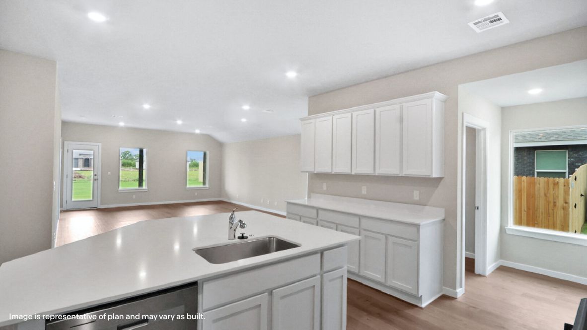 Bright and spacious kitchen with quartz countertops, stainless steel appliances, and an island with bar seating.