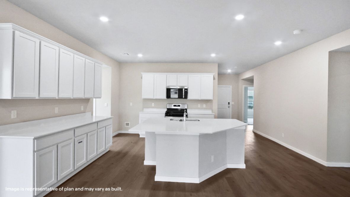 Bright and spacious kitchen with quartz countertops, stainless steel appliances, and an island with bar seating.