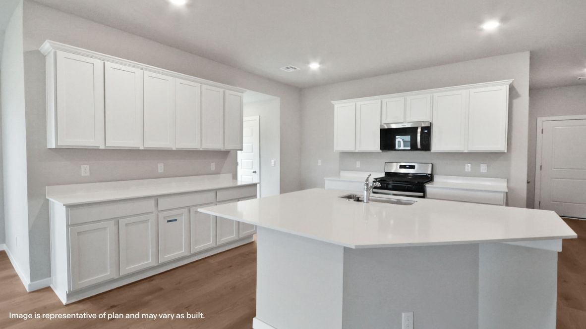 Bright and spacious kitchen with quartz countertops, stainless steel appliances, and an island with bar seating.