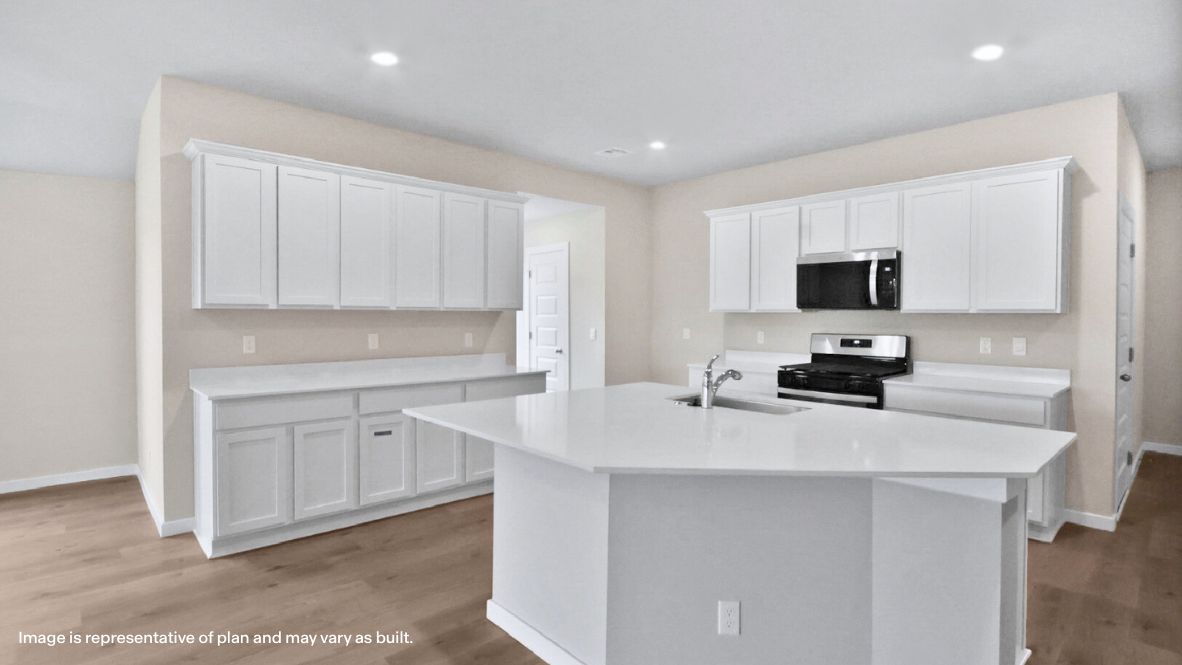Bright and spacious kitchen with quartz countertops, stainless steel appliances, and an island with bar seating.