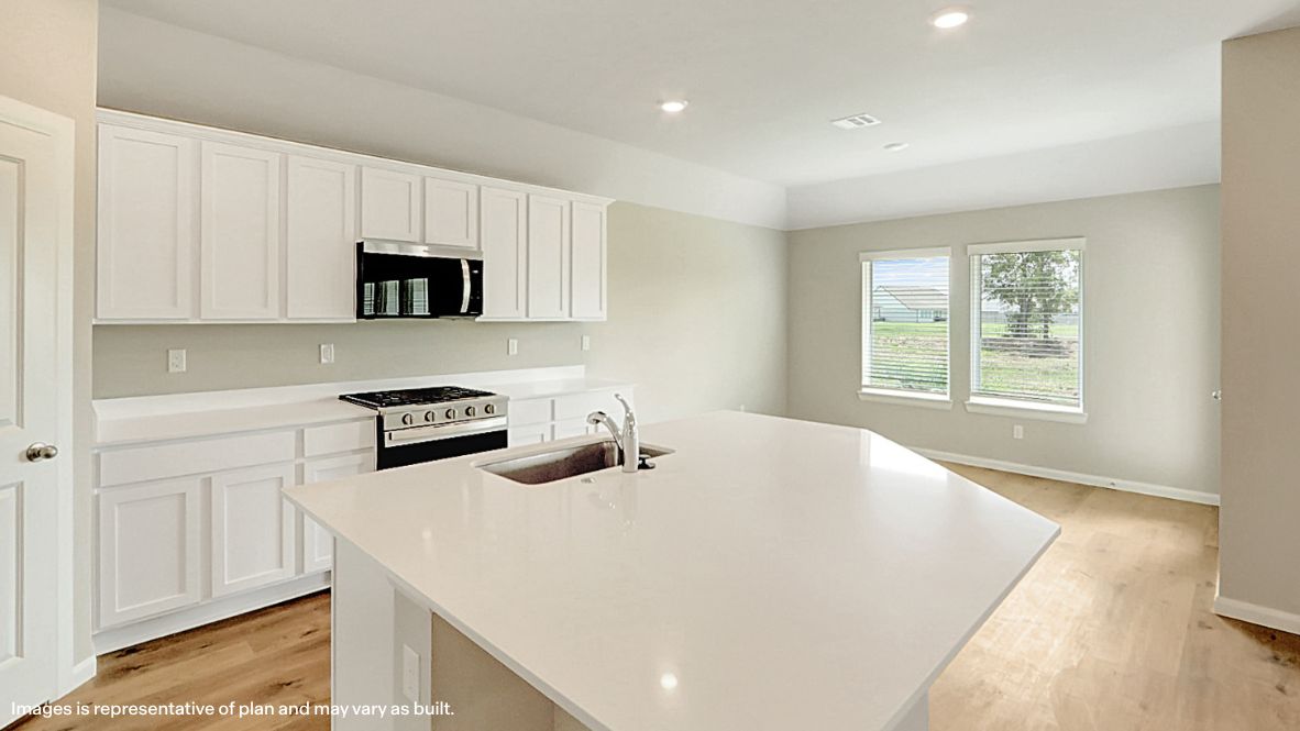 Contemporary kitchen adorned with white cabinets seamlessly integrated into an open dining area layout.