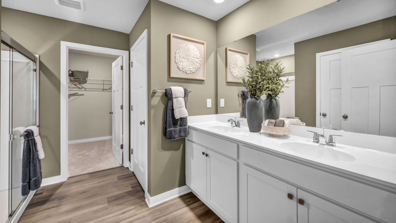 Dual vanity in the primary bath leads to a large walk in closet and separate water closet