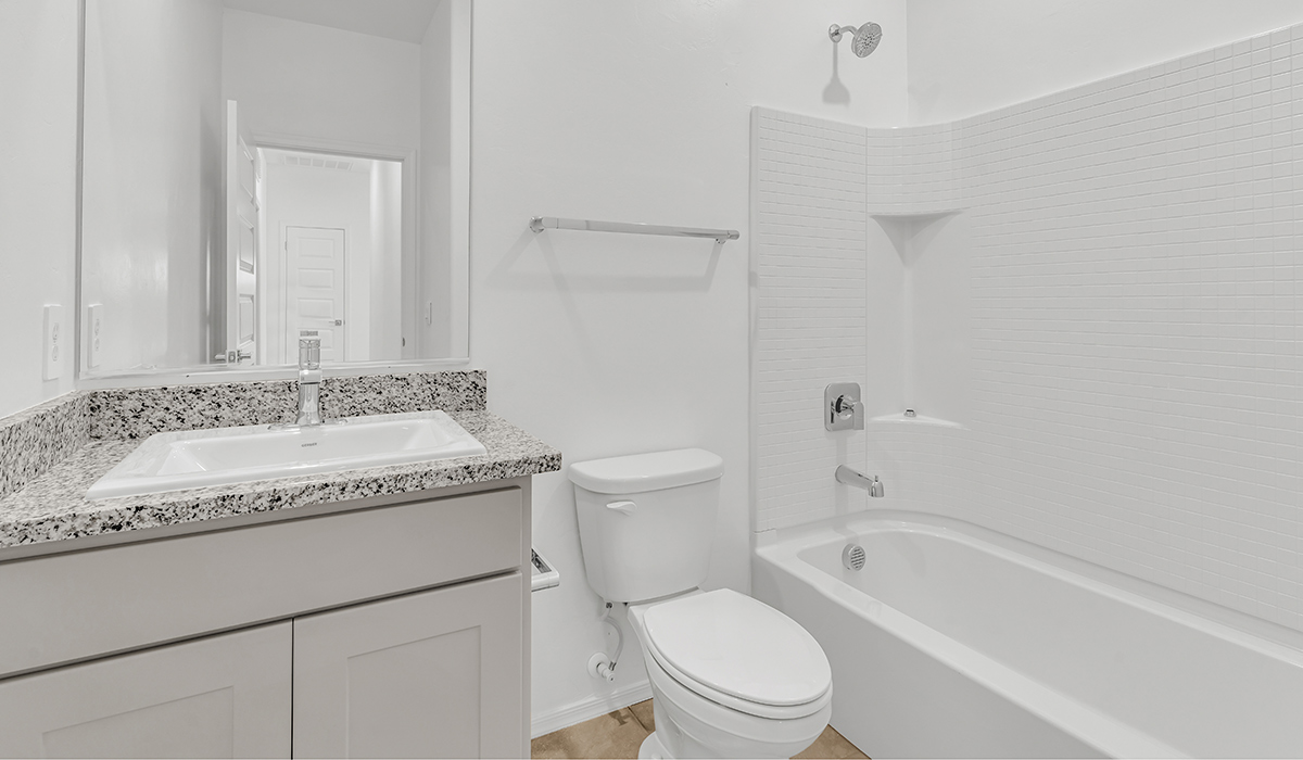 Welcome to The Amber at Coronet at Gladden Farms in Marana, Arizona – a thoughtfully designed 1,330 sq. ft. single-story new home that perfectly combines modern convenience with the natural beauty of the surrounding landscape.  As you step through the inviting front porch, you’re greeted by a smartly arranged entryway that opens into the heart of the home. The great room serves as the central gathering place, seamlessly connecting to the dining area and kitchen, creating an open and inviting space that’s perfect for both everyday living and entertaining.  The kitchen, designed with both style and functionality in mind, features quartz countertops, modern appliances, and a pantry that provides ample storage. The adjacent dining area offers a comfortable setting for meals, while the open layout ensures that the kitchen, dining, and living spaces are always connected.  At the rear of the home, the primary suite offers a peaceful retreat. The spacious bedroom leads to a well-appointed en-suite bathroom, complete with dual vanities, a walk-in shower, and a large walk-in closet, providing both comfort and convenience.  The Amber also includes two additional bedrooms, each offering plenty of space and natural light. These rooms are conveniently located near a second full bathroom, making them ideal for family members or guests.  Additional features of the home include a utility room and direct access to a two-car garage, adding practicality to the overall design. Step outside to the covered patio, where you can enjoy the stunning Arizona sunsets and the tranquil surroundings of Coronet at Gladden Farms.  Built with energy efficiency in mind, The Amber at Coronet at Gladden Farms is a DOE Zero Energy Ready Home, offering a sustainable lifestyle with lower utility costs and a reduced environmental footprint.