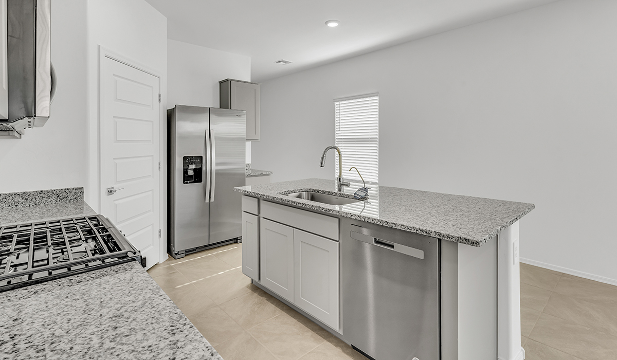 Welcome to The Amber at Coronet at Gladden Farms in Marana, Arizona – a thoughtfully designed 1,330 sq. ft. single-story new home that perfectly combines modern convenience with the natural beauty of the surrounding landscape.  As you step through the inviting front porch, you’re greeted by a smartly arranged entryway that opens into the heart of the home. The great room serves as the central gathering place, seamlessly connecting to the dining area and kitchen, creating an open and inviting space that’s perfect for both everyday living and entertaining.  The kitchen, designed with both style and functionality in mind, features quartz countertops, modern appliances, and a pantry that provides ample storage. The adjacent dining area offers a comfortable setting for meals, while the open layout ensures that the kitchen, dining, and living spaces are always connected.  At the rear of the home, the primary suite offers a peaceful retreat. The spacious bedroom leads to a well-appointed en-suite bathroom, complete with dual vanities, a walk-in shower, and a large walk-in closet, providing both comfort and convenience.  The Amber also includes two additional bedrooms, each offering plenty of space and natural light. These rooms are conveniently located near a second full bathroom, making them ideal for family members or guests.  Additional features of the home include a utility room and direct access to a two-car garage, adding practicality to the overall design. Step outside to the covered patio, where you can enjoy the stunning Arizona sunsets and the tranquil surroundings of Coronet at Gladden Farms.  Built with energy efficiency in mind, The Amber at Coronet at Gladden Farms is a DOE Zero Energy Ready Home, offering a sustainable lifestyle with lower utility costs and a reduced environmental footprint.