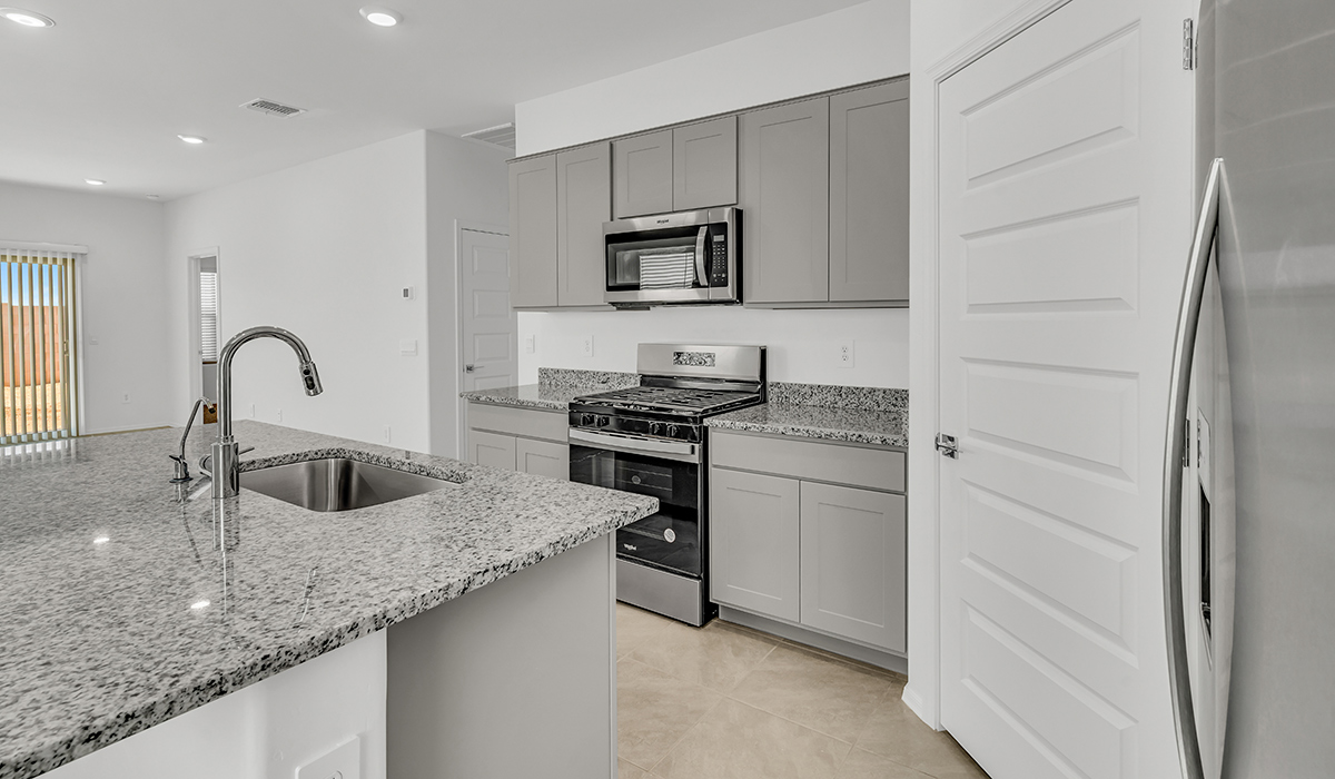 Welcome to The Amber at Coronet at Gladden Farms in Marana, Arizona – a thoughtfully designed 1,330 sq. ft. single-story new home that perfectly combines modern convenience with the natural beauty of the surrounding landscape.  As you step through the inviting front porch, you’re greeted by a smartly arranged entryway that opens into the heart of the home. The great room serves as the central gathering place, seamlessly connecting to the dining area and kitchen, creating an open and inviting space that’s perfect for both everyday living and entertaining.  The kitchen, designed with both style and functionality in mind, features quartz countertops, modern appliances, and a pantry that provides ample storage. The adjacent dining area offers a comfortable setting for meals, while the open layout ensures that the kitchen, dining, and living spaces are always connected.  At the rear of the home, the primary suite offers a peaceful retreat. The spacious bedroom leads to a well-appointed en-suite bathroom, complete with dual vanities, a walk-in shower, and a large walk-in closet, providing both comfort and convenience.  The Amber also includes two additional bedrooms, each offering plenty of space and natural light. These rooms are conveniently located near a second full bathroom, making them ideal for family members or guests.  Additional features of the home include a utility room and direct access to a two-car garage, adding practicality to the overall design. Step outside to the covered patio, where you can enjoy the stunning Arizona sunsets and the tranquil surroundings of Coronet at Gladden Farms.  Built with energy efficiency in mind, The Amber at Coronet at Gladden Farms is a DOE Zero Energy Ready Home, offering a sustainable lifestyle with lower utility costs and a reduced environmental footprint.