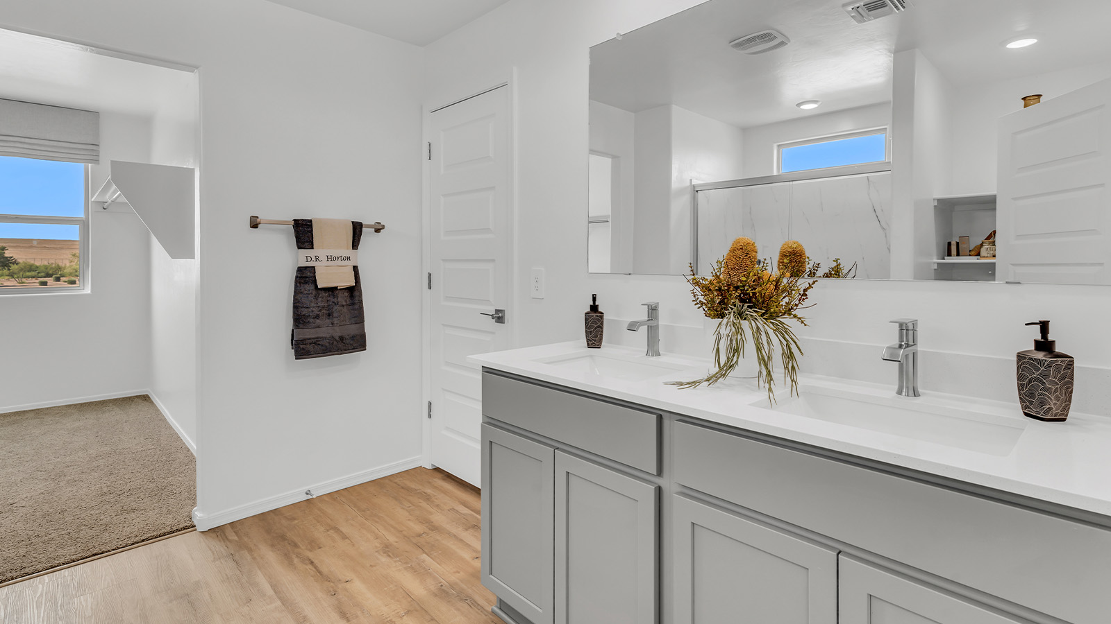 Welcome to The Kate at Coronet at Gladden Farms in Marana, Arizona – a spacious 2,227 sq. ft. two-story home designed to offer both luxury and practicality in a vibrant community setting.  As you step through the welcoming front porch, you’re greeted by an expansive entryway that leads into the heart of the home. The main floor features a generous great room that seamlessly flows into the dining area and kitchen, creating a perfect space for family gatherings and entertaining guests. The kitchen is a chef’s delight, boasting quartz countertops, a large island with a breakfast bar, modern appliances, and a walk-in pantry that provides ample storage.  The main floor also includes a convenient powder room for guests and direct access to the two-car garage, enhancing the home’s functionality. Just off the kitchen and dining room, a covered patio invites you to enjoy the beautiful Arizona weather, offering a serene spot for outdoor dining or relaxation.  Upstairs, the master suite offers a peaceful retreat, complete with a spacious bedroom, a large walk-in closet, and an en-suite bathroom featuring dual vanities and a walk-in shower. The upper level also includes three additional bedrooms, a full bathroom, and a centrally located utility room for added convenience. A versatile loft area provides additional living space, perfect for a playroom, home office, or secondary lounge.  The Kate in Coronet at Gladden Farms is designed with energy efficiency at its core. This DOE Zero Energy Ready Home features advanced energy-saving technologies such as tankless water heaters, energy-efficient LED lighting, and high-performance spray foam insulation, ensuring lower utility costs and a reduced environmental footprint.  Living at Coronet at Gladden Farms means more than just having a beautiful home. Residents enjoy access to 830 acres of green space, 28 parks, 19 playgrounds, and exclusive amenities like a sparkling community pool, fitness center, and clubhouse. The gated community also offers walking trails, a dog park, and close proximity to everyday conveniences, making it an ideal environment for families and active lifestyles.