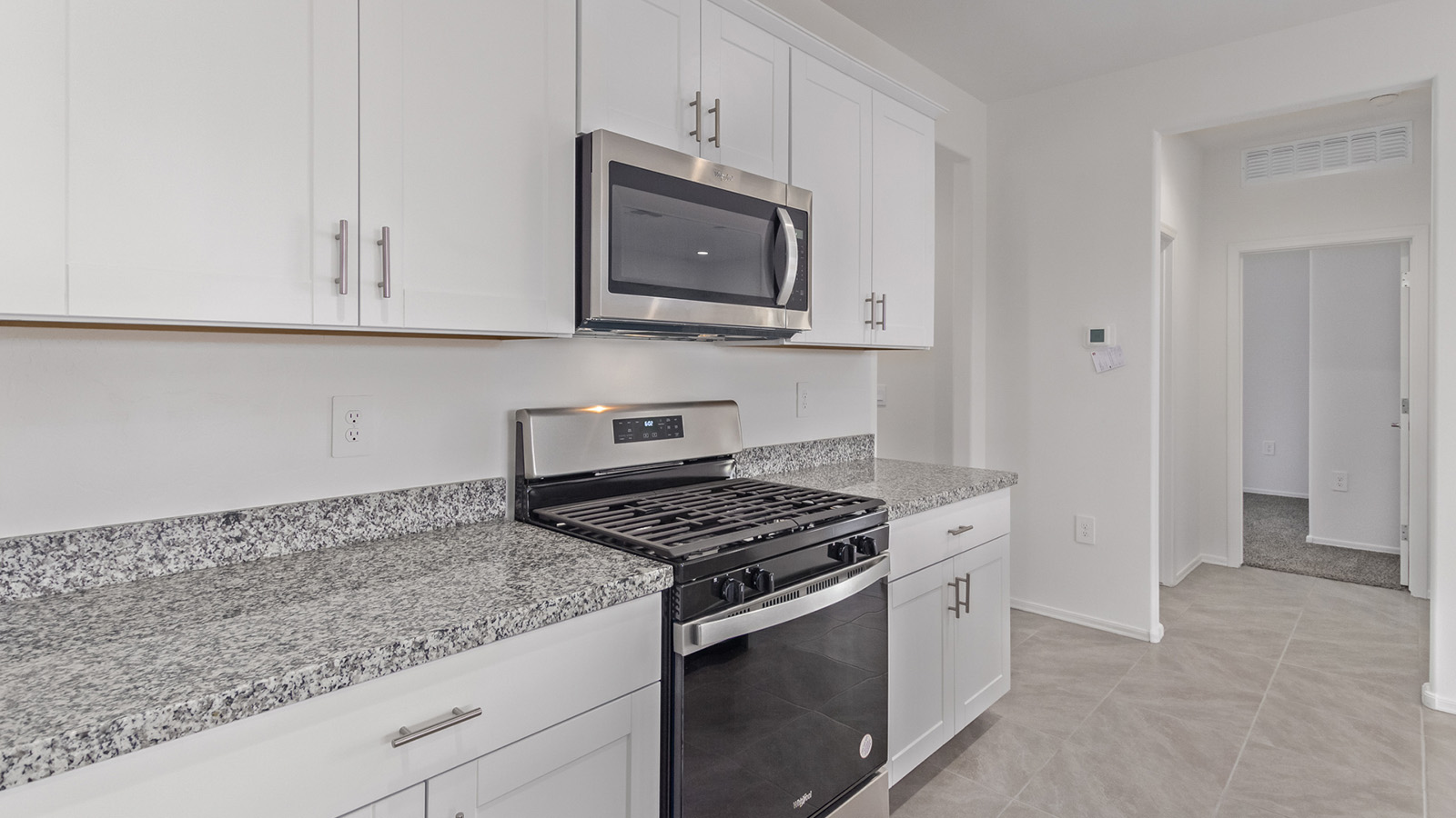 Welcome to The Madison within Coronet at Gladden Farms in Marana, Arizona – the largest new home in the community, offering an expansive 2,542 sq. ft. of living space designed to meet the needs of modern families.  As you step through the front porch, you’re welcomed into an entryway that opens up to the heart of the home. The main floor features a spacious great room that flows seamlessly into the dining area and kitchen, making it an ideal space for family gatherings and entertaining. The kitchen is a standout with its quartz countertops, large island, modern appliances, and a walk-in pantry.  On the main level, you'll also find a convenient bedroom and full bathroom, perfect for guests or as a private office space. The main floor’s design ensures both comfort and functionality, with direct access to the two-car garage and a covered patio that extends your living space outdoors.  Upstairs, the master suite offers a true retreat. The spacious bedroom leads to a large walk-in closet and an en-suite bathroom featuring dual vanities and a walk-in shower. The upper level also includes three additional bedrooms, a full bathroom, and a versatile loft area that can serve as a game room, home office, or second living area. A centrally located utility room adds convenience to everyday living.  Living at Coronet at Gladden Farms offers more than just a beautiful home. Residents enjoy exclusive amenities like a sparkling community pool, jacuzzi, fitness center, and clubhouse, along with access to 830 acres of green space, parks, playgrounds, and walking trails. This community is perfect for families who appreciate both comfort and outdoor adventure.  The Madison at Coronet at Gladden Farms is built with energy efficiency in mind, meeting DOE Zero Energy Ready Home standards. This means advanced features like tankless water heaters, energy-efficient LED lighting, and high-performance insulation are standard, ensuring lower utility costs and a reduced environmental footprint.