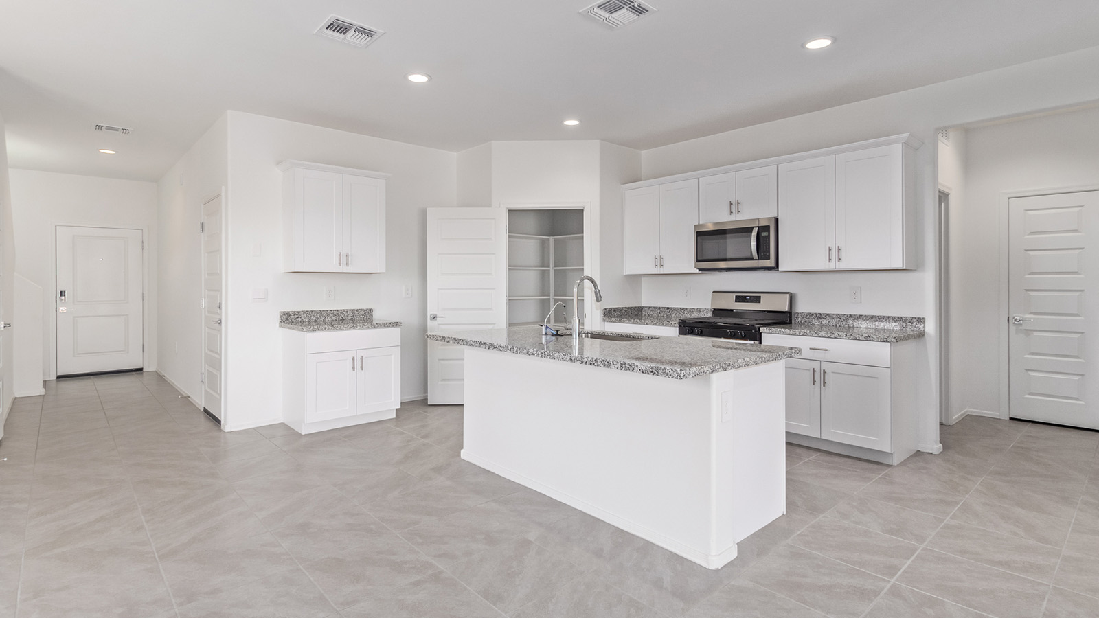 Welcome to The Madison within Coronet at Gladden Farms in Marana, Arizona – the largest new home in the community, offering an expansive 2,542 sq. ft. of living space designed to meet the needs of modern families.  As you step through the front porch, you’re welcomed into an entryway that opens up to the heart of the home. The main floor features a spacious great room that flows seamlessly into the dining area and kitchen, making it an ideal space for family gatherings and entertaining. The kitchen is a standout with its quartz countertops, large island, modern appliances, and a walk-in pantry.  On the main level, you'll also find a convenient bedroom and full bathroom, perfect for guests or as a private office space. The main floor’s design ensures both comfort and functionality, with direct access to the two-car garage and a covered patio that extends your living space outdoors.  Upstairs, the master suite offers a true retreat. The spacious bedroom leads to a large walk-in closet and an en-suite bathroom featuring dual vanities and a walk-in shower. The upper level also includes three additional bedrooms, a full bathroom, and a versatile loft area that can serve as a game room, home office, or second living area. A centrally located utility room adds convenience to everyday living.  Living at Coronet at Gladden Farms offers more than just a beautiful home. Residents enjoy exclusive amenities like a sparkling community pool, jacuzzi, fitness center, and clubhouse, along with access to 830 acres of green space, parks, playgrounds, and walking trails. This community is perfect for families who appreciate both comfort and outdoor adventure.  The Madison at Coronet at Gladden Farms is built with energy efficiency in mind, meeting DOE Zero Energy Ready Home standards. This means advanced features like tankless water heaters, energy-efficient LED lighting, and high-performance insulation are standard, ensuring lower utility costs and a reduced environmental footprint.