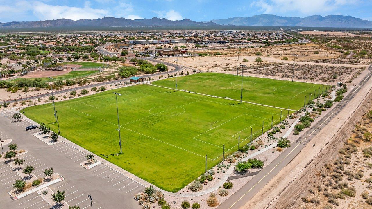 Welcome to The Madison within Coronet at Gladden Farms in Marana, Arizona – the largest new home in the community, offering an expansive 2,542 sq. ft. of living space designed to meet the needs of modern families.  As you step through the front porch, you’re welcomed into an entryway that opens up to the heart of the home. The main floor features a spacious great room that flows seamlessly into the dining area and kitchen, making it an ideal space for family gatherings and entertaining. The kitchen is a standout with its quartz countertops, large island, modern appliances, and a walk-in pantry.  On the main level, you'll also find a convenient bedroom and full bathroom, perfect for guests or as a private office space. The main floor’s design ensures both comfort and functionality, with direct access to the two-car garage and a covered patio that extends your living space outdoors.  Upstairs, the master suite offers a true retreat. The spacious bedroom leads to a large walk-in closet and an en-suite bathroom featuring dual vanities and a walk-in shower. The upper level also includes three additional bedrooms, a full bathroom, and a versatile loft area that can serve as a game room, home office, or second living area. A centrally located utility room adds convenience to everyday living.  Living at Coronet at Gladden Farms offers more than just a beautiful home. Residents enjoy exclusive amenities like a sparkling community pool, jacuzzi, fitness center, and clubhouse, along with access to 830 acres of green space, parks, playgrounds, and walking trails. This community is perfect for families who appreciate both comfort and outdoor adventure.  The Madison at Coronet at Gladden Farms is built with energy efficiency in mind, meeting DOE Zero Energy Ready Home standards. This means advanced features like tankless water heaters, energy-efficient LED lighting, and high-performance insulation are standard, ensuring lower utility costs and a reduced environmental footprint.