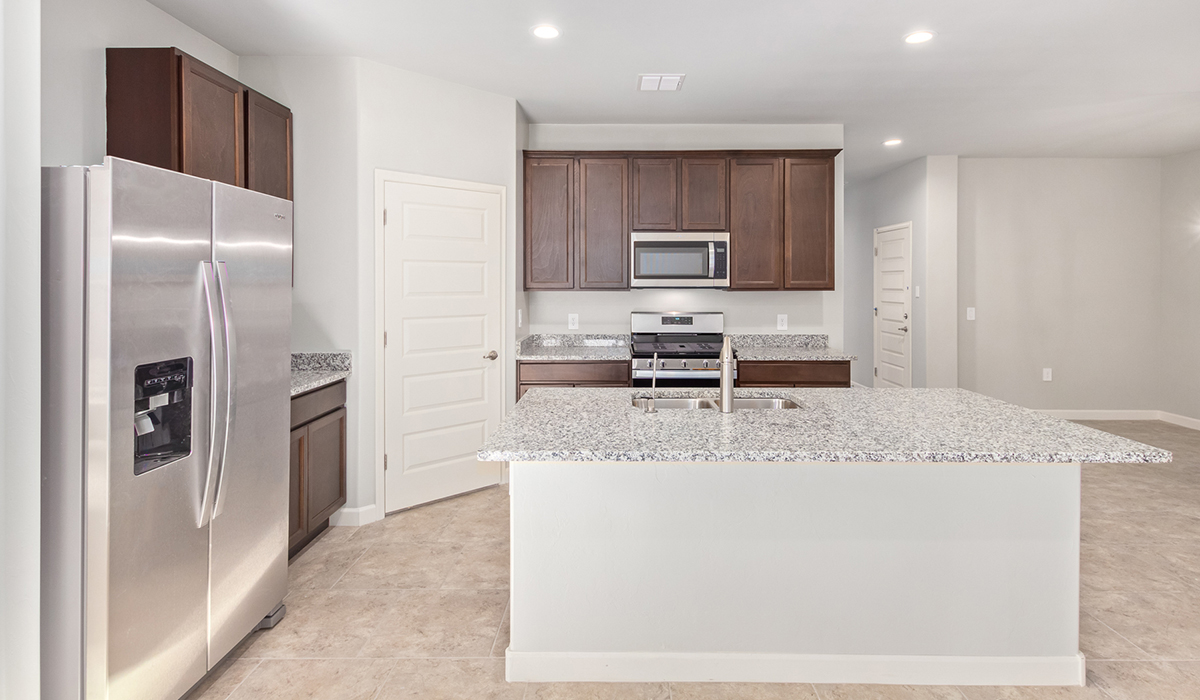 The Lakeway, situated within the beautiful Sycamore Vista community in Vail, Arizona, offers a perfect blend of functionality and comfort, ideal for both growing families and those who appreciate spacious living. With its 2,034 square feet of living space, this single-story new home features five bedrooms and three bathrooms, all meticulously designed to maximize space and convenience.  Entering The Lakeway, you’ll immediately notice the bright and airy atmosphere that flows through the open-concept floor plan. The heart of the home is the great room, seamlessly connected to the kitchen and dining area. The kitchen is equipped with quartz countertops, Shaker-style cabinetry, and a large island that serves as a focal point for both meal preparation and casual gatherings.  The primary bedroom is a true retreat, offering a spacious walk-in closet and an en-suite bathroom. The additional bedrooms are thoughtfully spaced to provide ample privacy for family members or guests, and the two secondary bathrooms are finished with modern fixtures and plenty of storage. This home offers a three-car garage option for substantial space of vehicles and storage, accommodating the practical needs of busy households.  Standard features in The Lakeway at Sycamore Vista include energy-efficient elements like a tankless water heater, spray foam insulation, and LED lighting throughout. The home also comes with a Home is Connected® Smart Home package, which includes a smart thermostat, video doorbell, keyless entry, and more, ensuring modern conveniences are at your fingertips. The front yard is beautifully landscaped and includes an auto drip irrigation system, enhancing the curb appeal of this stunning home.  Nestled within Sycamore Vista, The Lakeway combines the tranquility of a rural setting with proximity to excellent schools, shopping, dining, and outdoor recreation, making it an exceptional place to call home.  *Images shown are for reference only. They depict the model home and may not represent the actual home.