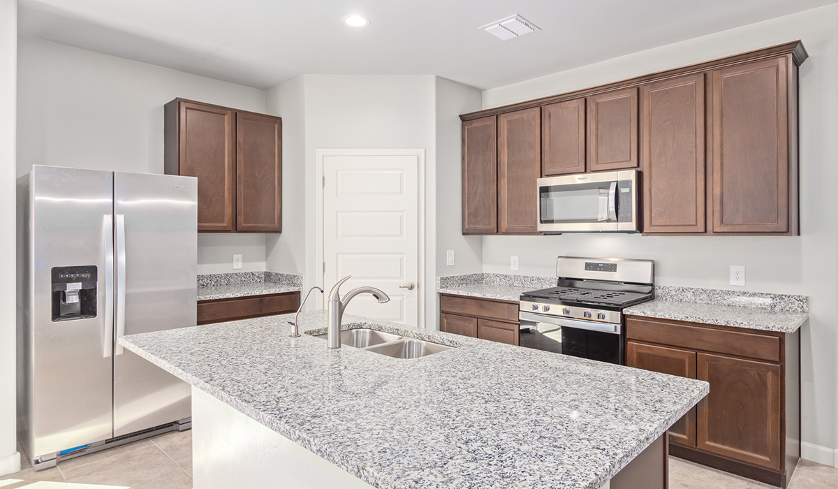 The Lakeway, situated within the beautiful Sycamore Vista community in Vail, Arizona, offers a perfect blend of functionality and comfort, ideal for both growing families and those who appreciate spacious living. With its 2,034 square feet of living space, this single-story new home features five bedrooms and three bathrooms, all meticulously designed to maximize space and convenience.  Entering The Lakeway, you’ll immediately notice the bright and airy atmosphere that flows through the open-concept floor plan. The heart of the home is the great room, seamlessly connected to the kitchen and dining area. The kitchen is equipped with quartz countertops, Shaker-style cabinetry, and a large island that serves as a focal point for both meal preparation and casual gatherings.  The primary bedroom is a true retreat, offering a spacious walk-in closet and an en-suite bathroom. The additional bedrooms are thoughtfully spaced to provide ample privacy for family members or guests, and the two secondary bathrooms are finished with modern fixtures and plenty of storage. This home offers a three-car garage option for substantial space of vehicles and storage, accommodating the practical needs of busy households.  Standard features in The Lakeway at Sycamore Vista include energy-efficient elements like a tankless water heater, spray foam insulation, and LED lighting throughout. The home also comes with a Home is Connected® Smart Home package, which includes a smart thermostat, video doorbell, keyless entry, and more, ensuring modern conveniences are at your fingertips. The front yard is beautifully landscaped and includes an auto drip irrigation system, enhancing the curb appeal of this stunning home.  Nestled within Sycamore Vista, The Lakeway combines the tranquility of a rural setting with proximity to excellent schools, shopping, dining, and outdoor recreation, making it an exceptional place to call home.  *Images shown are for reference only. They depict the model home and may not represent the actual home.