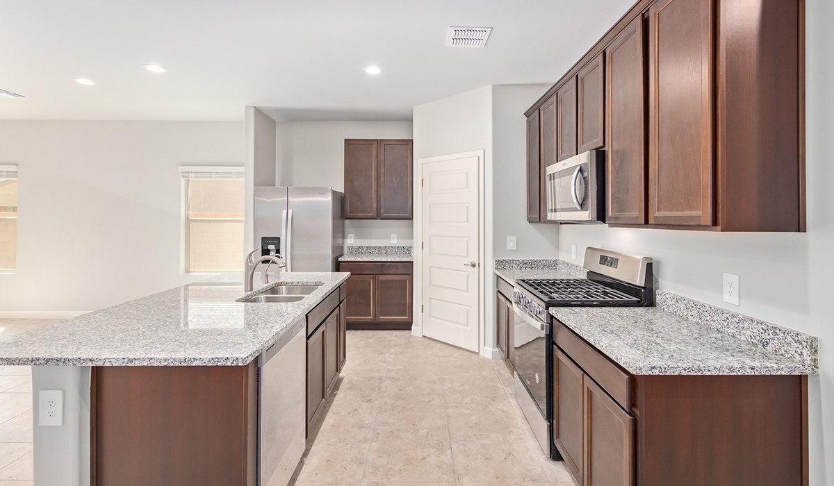 The Lakeway, situated within the beautiful Sycamore Vista community in Vail, Arizona, offers a perfect blend of functionality and comfort, ideal for both growing families and those who appreciate spacious living. With its 2,034 square feet of living space, this single-story new home features five bedrooms and three bathrooms, all meticulously designed to maximize space and convenience.  Entering The Lakeway, you’ll immediately notice the bright and airy atmosphere that flows through the open-concept floor plan. The heart of the home is the great room, seamlessly connected to the kitchen and dining area. The kitchen is equipped with quartz countertops, Shaker-style cabinetry, and a large island that serves as a focal point for both meal preparation and casual gatherings.  The primary bedroom is a true retreat, offering a spacious walk-in closet and an en-suite bathroom. The additional bedrooms are thoughtfully spaced to provide ample privacy for family members or guests, and the two secondary bathrooms are finished with modern fixtures and plenty of storage. This home offers a three-car garage option for substantial space of vehicles and storage, accommodating the practical needs of busy households.  Standard features in The Lakeway at Sycamore Vista include energy-efficient elements like a tankless water heater, spray foam insulation, and LED lighting throughout. The home also comes with a Home is Connected® Smart Home package, which includes a smart thermostat, video doorbell, keyless entry, and more, ensuring modern conveniences are at your fingertips. The front yard is beautifully landscaped and includes an auto drip irrigation system, enhancing the curb appeal of this stunning home.  Nestled within Sycamore Vista, The Lakeway combines the tranquility of a rural setting with proximity to excellent schools, shopping, dining, and outdoor recreation, making it an exceptional place to call home.  *Images shown are for reference only. They depict the model home and may not represent the actual home.