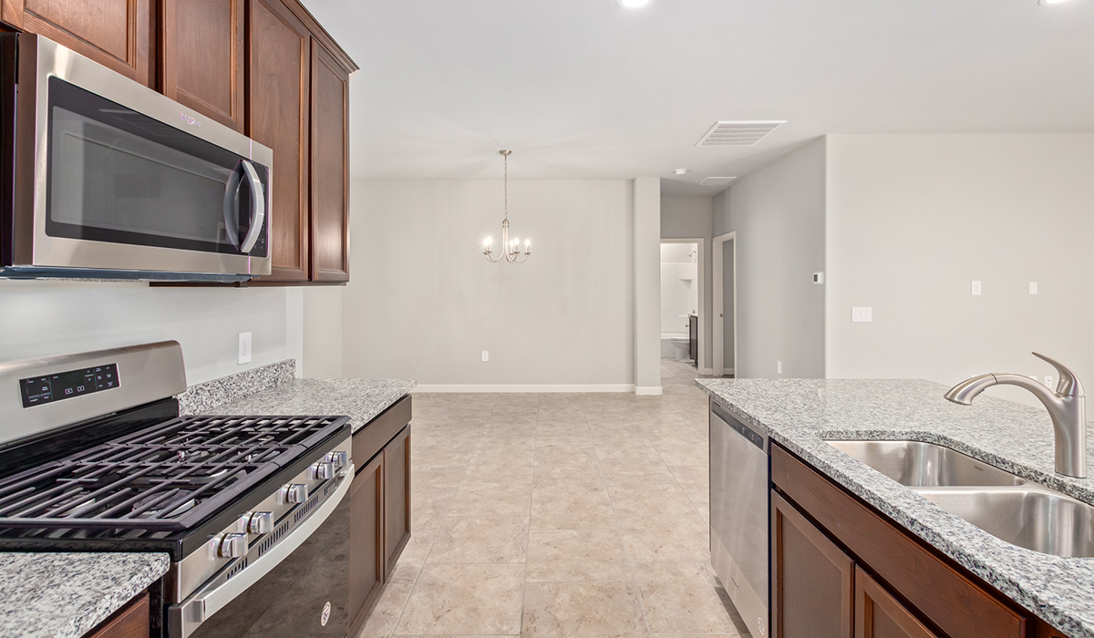 The Lakeway, situated within the beautiful Sycamore Vista community in Vail, Arizona, offers a perfect blend of functionality and comfort, ideal for both growing families and those who appreciate spacious living. With its 2,034 square feet of living space, this single-story new home features five bedrooms and three bathrooms, all meticulously designed to maximize space and convenience.  Entering The Lakeway, you’ll immediately notice the bright and airy atmosphere that flows through the open-concept floor plan. The heart of the home is the great room, seamlessly connected to the kitchen and dining area. The kitchen is equipped with quartz countertops, Shaker-style cabinetry, and a large island that serves as a focal point for both meal preparation and casual gatherings.  The primary bedroom is a true retreat, offering a spacious walk-in closet and an en-suite bathroom. The additional bedrooms are thoughtfully spaced to provide ample privacy for family members or guests, and the two secondary bathrooms are finished with modern fixtures and plenty of storage. This home offers a three-car garage option for substantial space of vehicles and storage, accommodating the practical needs of busy households.  Standard features in The Lakeway at Sycamore Vista include energy-efficient elements like a tankless water heater, spray foam insulation, and LED lighting throughout. The home also comes with a Home is Connected® Smart Home package, which includes a smart thermostat, video doorbell, keyless entry, and more, ensuring modern conveniences are at your fingertips. The front yard is beautifully landscaped and includes an auto drip irrigation system, enhancing the curb appeal of this stunning home.  Nestled within Sycamore Vista, The Lakeway combines the tranquility of a rural setting with proximity to excellent schools, shopping, dining, and outdoor recreation, making it an exceptional place to call home.  *Images shown are for reference only. They depict the model home and may not represent the actual home.