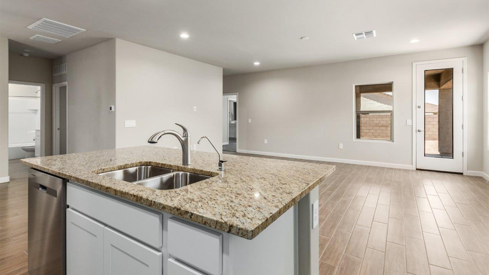 The Lakeway, situated within the beautiful Sycamore Vista community in Vail, Arizona, offers a perfect blend of functionality and comfort, ideal for both growing families and those who appreciate spacious living. With its 2,034 square feet of living space, this single-story new home features five bedrooms and three bathrooms, all meticulously designed to maximize space and convenience.  Entering The Lakeway, you’ll immediately notice the bright and airy atmosphere that flows through the open-concept floor plan. The heart of the home is the great room, seamlessly connected to the kitchen and dining area. The kitchen is equipped with quartz countertops, Shaker-style cabinetry, and a large island that serves as a focal point for both meal preparation and casual gatherings.  The primary bedroom is a true retreat, offering a spacious walk-in closet and an en-suite bathroom. The additional bedrooms are thoughtfully spaced to provide ample privacy for family members or guests, and the two secondary bathrooms are finished with modern fixtures and plenty of storage. This home offers a 2-3 car garage option for substantial space of vehicles and storage, accommodating the practical needs of busy households.  Standard features in The Lakeway at Sycamore Vista include energy-efficient elements like a tankless water heater, spray foam insulation, and LED lighting throughout. The home also comes with a Home is Connected® Smart Home package, which includes a smart thermostat, video doorbell, keyless entry, and more, ensuring modern conveniences are at your fingertips. The front yard is beautifully landscaped and includes an auto drip irrigation system, enhancing the curb appeal of this stunning home.  Nestled within Sycamore Vista, The Lakeway combines the tranquility of a rural setting with proximity to excellent schools, shopping, dining, and outdoor recreation, making it an exceptional place to call home.  *Images shown are for reference only. They depict the Lakeaymodel home and may not represent the actual home.