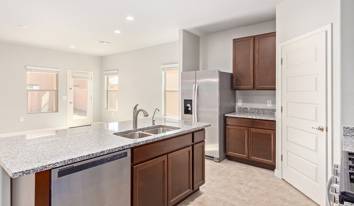 The Lakeway, situated within the beautiful Sycamore Vista community in Vail, Arizona, offers a perfect blend of functionality and comfort, ideal for both growing families and those who appreciate spacious living. With its 2,034 square feet of living space, this single-story new home features five bedrooms and three bathrooms, all meticulously designed to maximize space and convenience.  Entering The Lakeway, you’ll immediately notice the bright and airy atmosphere that flows through the open-concept floor plan. The heart of the home is the great room, seamlessly connected to the kitchen and dining area. The kitchen is equipped with quartz countertops, Shaker-style cabinetry, and a large island that serves as a focal point for both meal preparation and casual gatherings.  The primary bedroom is a true retreat, offering a spacious walk-in closet and an en-suite bathroom. The additional bedrooms are thoughtfully spaced to provide ample privacy for family members or guests, and the two secondary bathrooms are finished with modern fixtures and plenty of storage. This home offers a 2-3 car garage option for substantial space of vehicles and storage, accommodating the practical needs of busy households.  Standard features in The Lakeway at Sycamore Vista include energy-efficient elements like a tankless water heater, spray foam insulation, and LED lighting throughout. The home also comes with a Home is Connected® Smart Home package, which includes a smart thermostat, video doorbell, keyless entry, and more, ensuring modern conveniences are at your fingertips. The front yard is beautifully landscaped and includes an auto drip irrigation system, enhancing the curb appeal of this stunning home.  Nestled within Sycamore Vista, The Lakeway combines the tranquility of a rural setting with proximity to excellent schools, shopping, dining, and outdoor recreation, making it an exceptional place to call home.