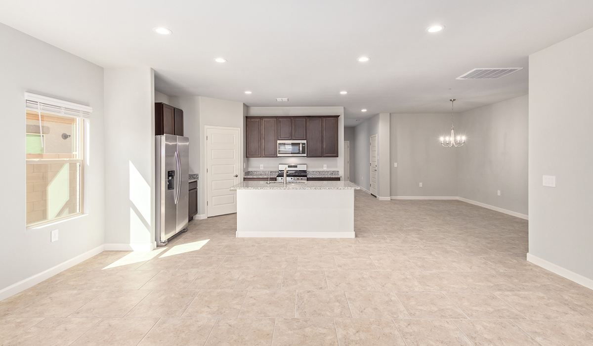 The Lakeway, situated within the beautiful Sycamore Vista community in Vail, Arizona, offers a perfect blend of functionality and comfort, ideal for both growing families and those who appreciate spacious living. With its 2,034 square feet of living space, this single-story new home features five bedrooms and three bathrooms, all meticulously designed to maximize space and convenience.  Entering The Lakeway, you’ll immediately notice the bright and airy atmosphere that flows through the open-concept floor plan. The heart of the home is the great room, seamlessly connected to the kitchen and dining area. The kitchen is equipped with quartz countertops, Shaker-style cabinetry, and a large island that serves as a focal point for both meal preparation and casual gatherings.  The primary bedroom is a true retreat, offering a spacious walk-in closet and an en-suite bathroom. The additional bedrooms are thoughtfully spaced to provide ample privacy for family members or guests, and the two secondary bathrooms are finished with modern fixtures and plenty of storage. This home offers a 2-3 car garage option for substantial space of vehicles and storage, accommodating the practical needs of busy households.  Standard features in The Lakeway at Sycamore Vista include energy-efficient elements like a tankless water heater, spray foam insulation, and LED lighting throughout. The home also comes with a Home is Connected® Smart Home package, which includes a smart thermostat, video doorbell, keyless entry, and more, ensuring modern conveniences are at your fingertips. The front yard is beautifully landscaped and includes an auto drip irrigation system, enhancing the curb appeal of this stunning home.  Nestled within Sycamore Vista, The Lakeway combines the tranquility of a rural setting with proximity to excellent schools, shopping, dining, and outdoor recreation, making it an exceptional place to call home.