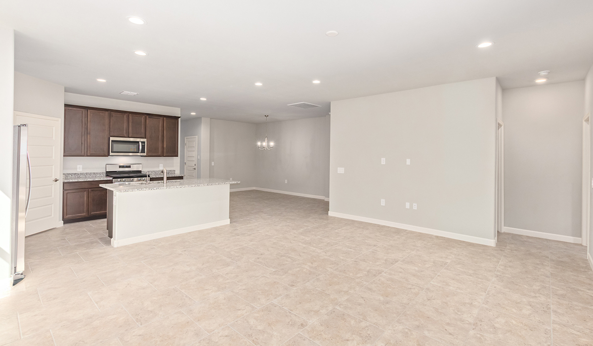 The Lakeway, situated within the beautiful Sycamore Vista community in Vail, Arizona, offers a perfect blend of functionality and comfort, ideal for both growing families and those who appreciate spacious living. With its 2,034 square feet of living space, this single-story new home features five bedrooms and three bathrooms, all meticulously designed to maximize space and convenience.  Entering The Lakeway, you’ll immediately notice the bright and airy atmosphere that flows through the open-concept floor plan. The heart of the home is the great room, seamlessly connected to the kitchen and dining area. The kitchen is equipped with quartz countertops, Shaker-style cabinetry, and a large island that serves as a focal point for both meal preparation and casual gatherings.  The primary bedroom is a true retreat, offering a spacious walk-in closet and an en-suite bathroom. The additional bedrooms are thoughtfully spaced to provide ample privacy for family members or guests, and the two secondary bathrooms are finished with modern fixtures and plenty of storage. This home offers a 2-3 car garage option for substantial space of vehicles and storage, accommodating the practical needs of busy households.  Standard features in The Lakeway at Sycamore Vista include energy-efficient elements like a tankless water heater, spray foam insulation, and LED lighting throughout. The home also comes with a Home is Connected® Smart Home package, which includes a smart thermostat, video doorbell, keyless entry, and more, ensuring modern conveniences are at your fingertips. The front yard is beautifully landscaped and includes an auto drip irrigation system, enhancing the curb appeal of this stunning home.  Nestled within Sycamore Vista, The Lakeway combines the tranquility of a rural setting with proximity to excellent schools, shopping, dining, and outdoor recreation, making it an exceptional place to call home.