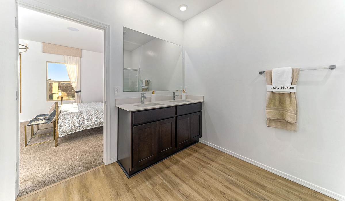 Welcome to the Kingston floor plan at Saguaro Bloom, Marana, Arizona, a perfect blend of comfort, modern living, and energy efficiency. This thoughtfully crafted one-story home spans 2,051 square feet and offers four bedrooms and two bathrooms, ideal for families of all sizes.  The open-concept design features a spacious great room that effortlessly connects with the kitchen and dining area, creating an inviting central hub for everyday living and entertaining. The kitchen is equipped with contemporary appliances and a pantry.  The primary bedroom, located at the rear of the home, provides a peaceful retreat with a private ensuite bathroom and a walk-in closet. The additional three bedrooms are positioned at the front of the house, offering versatility for use as guest rooms, a home office, or children’s bedrooms. Step outside to the covered patio, a perfect spot to enjoy the beautiful Arizona weather.  Built with energy efficiency as a priority, the Kingston includes smart home technology, which not only simplifies daily living but also helps reduce utility costs. A two-car garage provides ample parking and additional storage space, enhancing the home’s functionality.  Residents of Saguaro Bloom enjoy access to a range of community amenities, including parks, walking trails, and recreational facilities, making this home an ideal choice for those seeking a balanced lifestyle in a scenic setting.  *Images shown are for reference only. They depict The Kingston sales model home and may not represent the actual home.