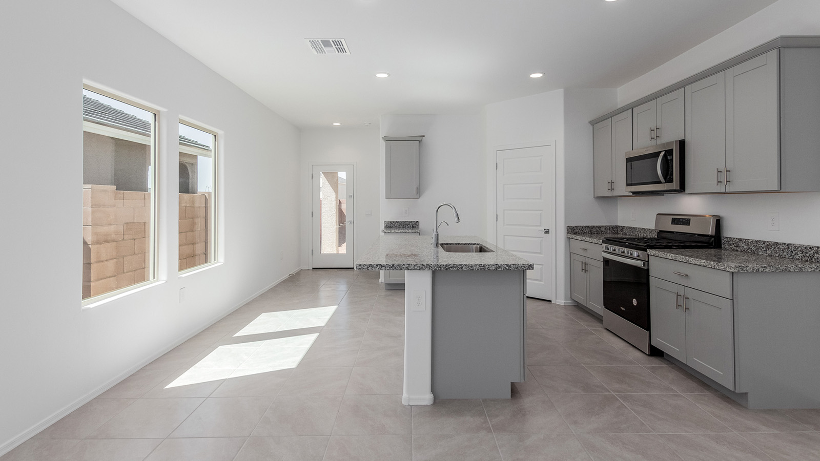 Welcome to The Diana, a beautifully designed single-story new home located in the Mesquite neighborhood at Saguaro Bloom, one of Marana’s premier master-planned communities. Spanning 1,558 square feet, The Diana offers an ideal balance of comfort and style, perfectly suited for modern living.  As you step inside, you are welcomed by an inviting entryway that leads into the heart of the home. The open layout is designed for convenience, with a spacious great room that seamlessly integrates with the dining area and kitchen, creating a central space perfect for everyday life and entertaining. The kitchen is a true centerpiece, featuring an island, quartz countertops, and stylish Shaker-style cabinetry, all working together to create a space that is practical and elegant.  The Diana offers three bedrooms and provides ample room for everyone in the household. The primary bedroom is thoughtfully positioned for privacy and comes with a walk-in closet and a private en-suite bathroom, offering a personal retreat at the end of the day. The two additional bedrooms are located near the front of the home, sharing a full bathroom, making this layout ideal for families or for extra guest space.  With a dedicated utility room conveniently situated near the entry and a spacious pantry just off the kitchen, The Diana is designed to meet the needs of today’s busy lifestyles. Large windows throughout the home allow natural light to fill the space, creating a bright and welcoming atmosphere.  Step outside to the covered patio, perfect for enjoying the Arizona climate. Whether you're hosting a summer barbecue or simply unwinding in the evening, this outdoor space is a valuable addition to the home.  Situated in the desirable Saguaro Bloom community, residents will enjoy access to a wide range of amenities, including community pools, walking trails, and parks, all surrounded by the natural beauty of the Tucson Mountains.