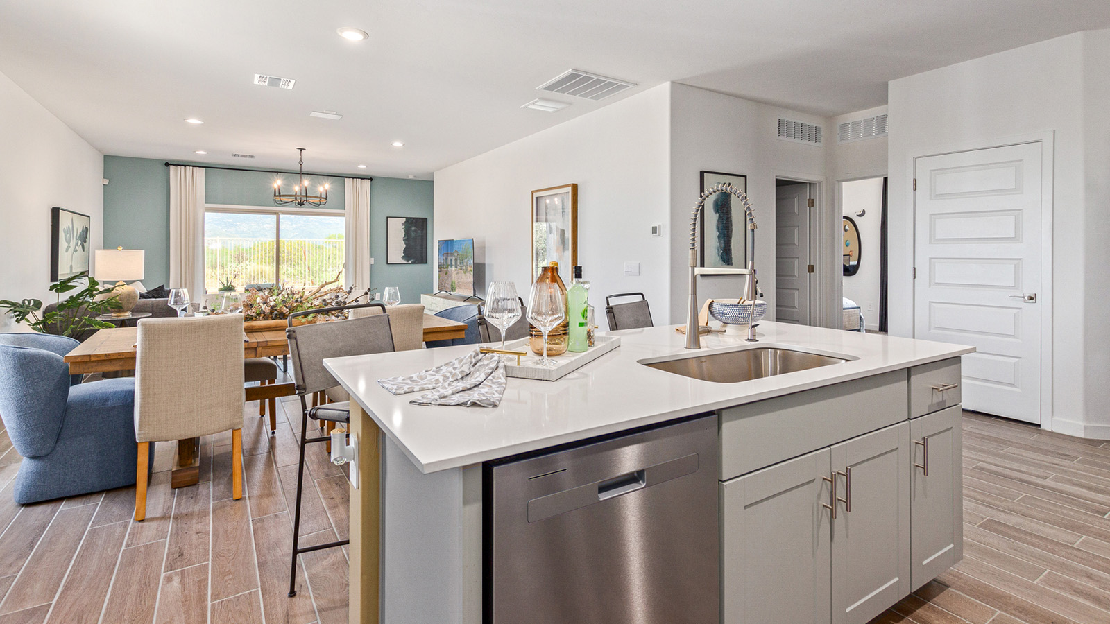 Welcome to the Gaven plan, a spacious single-story new home within Saguaro Bloom, where modern living meets the serene beauty of the Arizona landscape. This thoughtfully crafted residence offers 1,815 square feet of well-designed living space, featuring four bedrooms and two full bathrooms, perfect for families who value both comfort and style. As you step through the front door, you’ll be greeted by a bright and airy entryway that seamlessly transitions into the heart of the home. The open layout connects the great room, dining area, and kitchen, creating an ideal environment for both everyday living and entertaining. The kitchen is a culinary haven, equipped with state-of-the-art appliances, a spacious pantry, and elegant quartz countertops that extend to a large island, perfect for meal prep or casual dining.  The master suite, nestled at the rear of the home, offers a peaceful retreat with a generously sized walk-in closet and a luxurious en-suite bathroom. The additional three bedrooms are strategically placed to provide privacy and convenience, making them perfect for children, guests, or even a home office. Outside, the covered patio extends your living space into the beautifully landscaped backyard, ideal for enjoying Arizona’s stunning sunsets. The front yard is also fully landscaped and equipped with an auto drip irrigation system, ensuring your home’s curb appeal is maintained with ease.  Each home within Saguaro Bloom, including the Gaven plan, is outfitted with D.R. Horton’s Home is Connected® Smart Home package, featuring a smart thermostat, video doorbell, keyless entry, and Wi-Fi-enabled garage door opener. Energy efficiency is a cornerstone of the design, with features like spray foam insulation, tankless water heaters, and LED lighting, all contributing to long-term savings and environmental sustainability.  Saguaro Bloom isn’t just a place to live; it’s a vibrant community with a wealth of amenities, from scenic walking trails to pools and playgrounds, ensuring that there’s always something for everyone. Embrace the lifestyle you’ve always dreamed of in the Gaven plan—a perfect blend of comfort, convenience, and Arizona charm