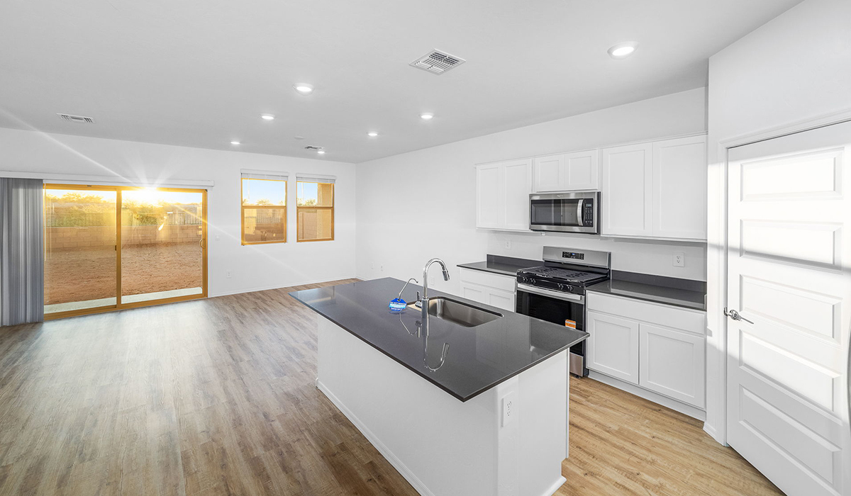 Discover The Easton at Saguaro Bloom in Marana, Arizona – a spacious 1,697 sq. ft. single-story new home designed to offer both style and functionality for today’s modern family.  As you enter through the front porch, you’re welcomed into a thoughtful layout that makes every square foot count. Near the front entrance is the first bedroom intentionally situated. This room can be utilized as a guest room, home office, or a cozy retreat.  Continuing down the hall you're welcomed into the great room, which flows seamlessly into the dining area and kitchen. This open-concept design ensures that the heart of the home is always connected. The kitchen is a culinary dream, featuring quartz countertops, a spacious island with a breakfast bar, and a walk-in pantry.  The great room opens up to a covered patio, an ideal space to unwind and enjoy beautiful desert sunsets. Whether you’re hosting a weekend barbecue or enjoying a quiet evening outdoors, this patio extends your living space into the scenic surroundings of Saguaro Bloom.  Just off the great room, a private hallway leads to the primary suite. The primary suite is generously sized and features a large walk-in closet, en-suite bathroom with walk-in shower, offering both privacy and convenience.  The Easton also features two additional bedrooms, well-positioned to share a full bathroom. These rooms are ideal for family members.  The Easton is designed with energy efficiency in mind and is DOE Zero Energy Ready Home Certified. This home includes a Connected® Smart Home package, featuring a smart thermostat, video doorbell, keyless entry, and Wi-Fi-enabled garage door opener. Energy efficiency is a cornerstone of the design, with features like spray foam insulation, and tankless water heater, offering long-term savings and sustainability.  Saguaro Bloom isn’t just a place to live, it’s a vibrant community with a wealth of amenities, from scenic walking trails to pools and playgrounds, ensuring that there’s always something for everyone.