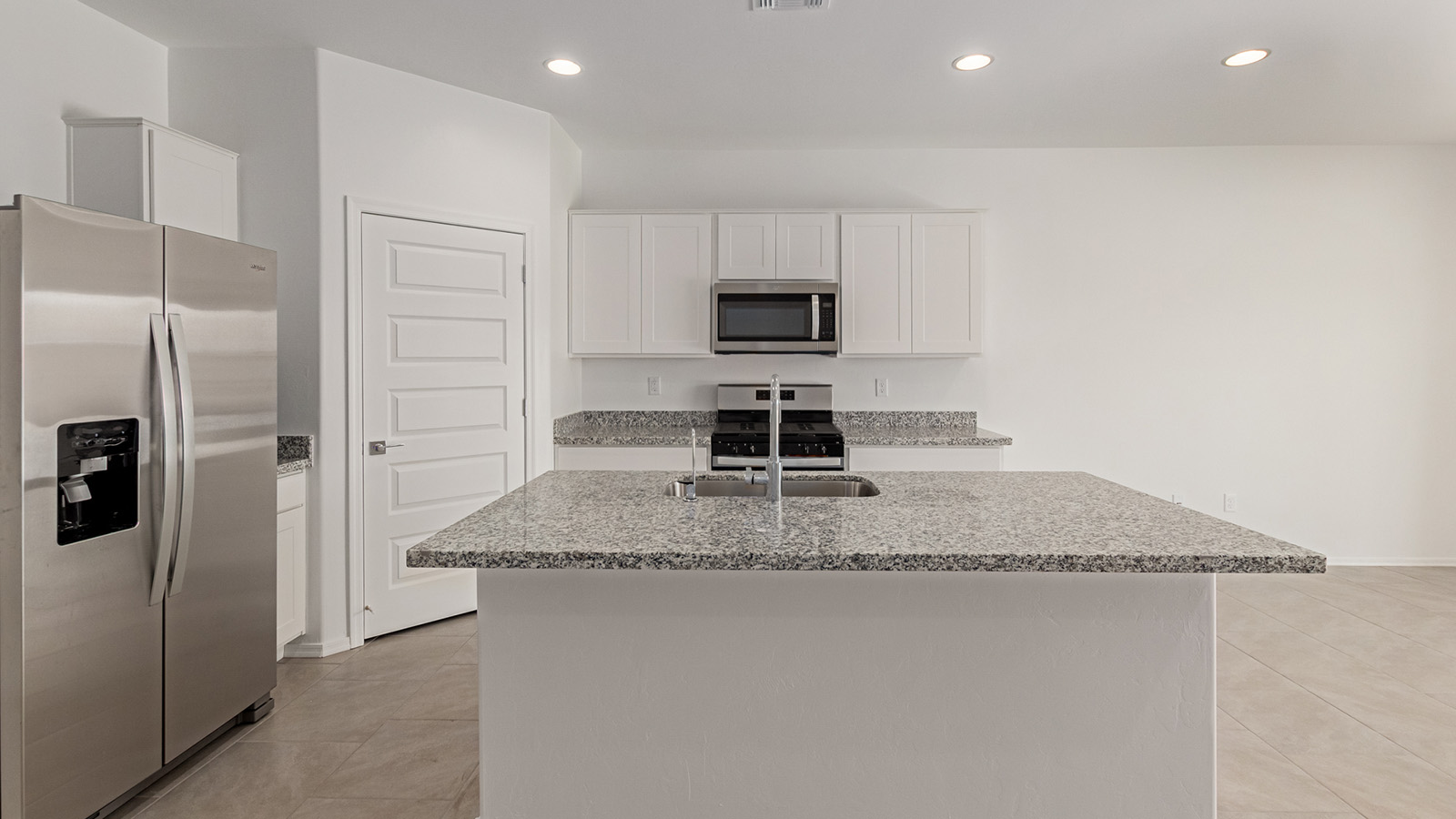 Discover The Easton at Saguaro Bloom in Marana, Arizona – a spacious 1,697 sq. ft. single-story new home designed to offer both style and functionality for today’s modern family.  As you enter through the front porch, you’re welcomed into a thoughtful layout that makes every square foot count. Near the front entrance is the first bedroom intentionally situated. This room can be utilized as a guest room, home office, or a cozy retreat.  Continuing down the hall you're welcomed into the great room, which flows seamlessly into the dining area and kitchen. This open-concept design ensures that the heart of the home is always connected. The kitchen is a culinary dream, featuring quartz countertops, a spacious island with a breakfast bar, and a walk-in pantry.  The great room opens up to a covered patio, an ideal space to unwind and enjoy beautiful desert sunsets. Whether you’re hosting a weekend barbecue or enjoying a quiet evening outdoors, this patio extends your living space into the scenic surroundings of Saguaro Bloom.  Just off the great room, a private hallway leads to the primary suite. The primary suite is generously sized and features a large walk-in closet, en-suite bathroom with walk-in shower, offering both privacy and convenience.  The Easton also features two additional bedrooms, well-positioned to share a full bathroom. These rooms are ideal for family members.  The Easton is designed with energy efficiency in mind and is DOE Zero Energy Ready Home Certified. This home includes a Connected® Smart Home package, featuring a smart thermostat, video doorbell, keyless entry, and Wi-Fi-enabled garage door opener. Energy efficiency is a cornerstone of the design, with features like spray foam insulation, and tankless water heater, offering long-term savings and sustainability.  Saguaro Bloom isn’t just a place to live, it’s a vibrant community with a wealth of amenities, from scenic walking trails to pools and playgrounds, ensuring that there’s always something for everyone.