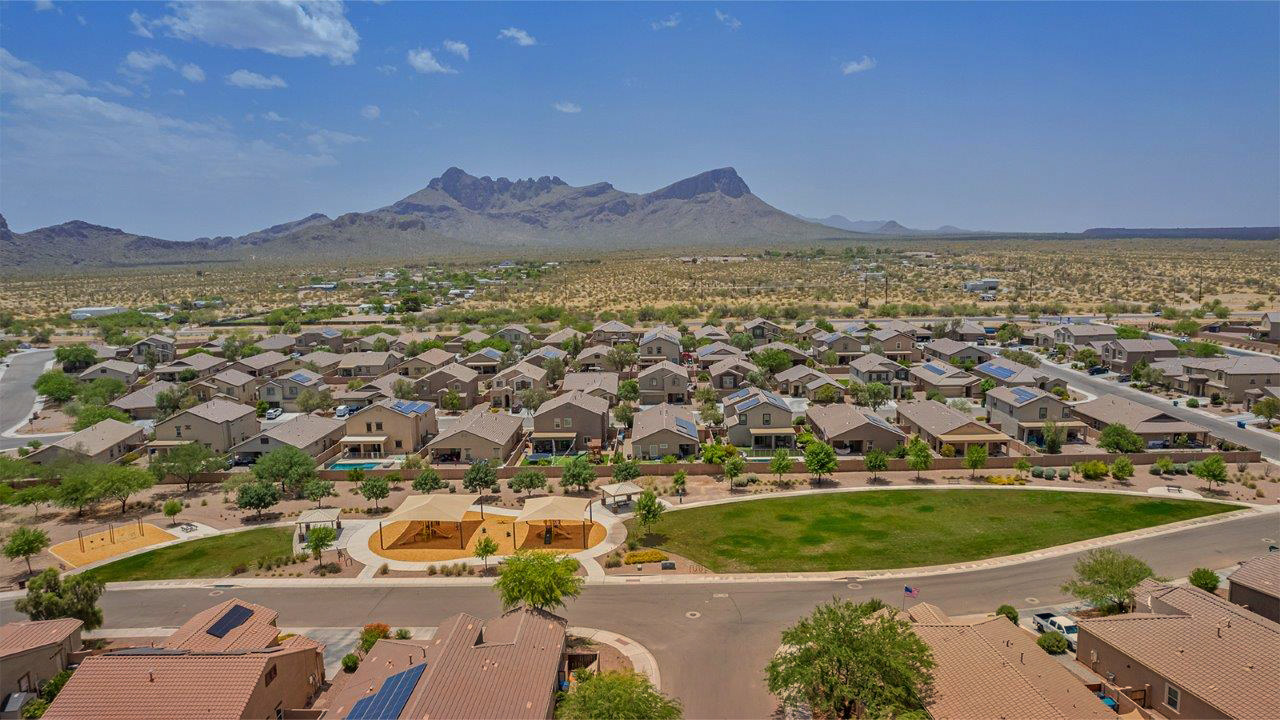Welcome to The Pearl, a beautifully designed single-story new home located in the serene Cholla Ridge neighborhood of Saguaro Bloom. Spanning 2,431 square feet, this home offers four spacious bedrooms and three full bathrooms, making it an ideal choice for families who value both space and comfort.  As you enter through the front porch, you’re welcomed into a bright and open entryway that leads to the heart of the home. The expansive great room, dining area, and kitchen are seamlessly connected, providing a perfect setting for both everyday living and entertaining. The kitchen is a chef’s delight, featuring a large island, granite countertops, and Shaker-style cabinetry in double espresso. With a generously sized pantry and modern stainless steel gas appliances, this kitchen is both functional and stylish.  The Pearl’s layout includes a well-placed primary bedroom at the rear of the home, ensuring privacy and tranquility. The primary suite features a spacious walk-in closet and an en-suite bathroom with dual executive-height vanities and a large walk-in shower. The additional three bedrooms are located towards the front and sides of the home, each offering ample closet space and access to two full bathrooms, making this layout perfect for families and guests alike.  The outdoor living space is just as inviting, with a covered patio that extends from the great room, providing an ideal spot for enjoying Arizona’s beautiful weather. Whether you’re hosting a gathering or simply relaxing with a good book, this space is designed for your enjoyment.  The Pearl also features a dedicated utility room near the kitchen, making household tasks more convenient. A two-car garage offers plenty of space for vehicles and additional storage.  Built with energy efficiency and modern living in mind, The Pearl incorporates eco-friendly features and smart home technology, ensuring a comfortable and sustainable lifestyle. Large windows throughout the home allow natural light to flood the space, creating a warm and inviting atmosphere.  Located within the exclusive Cholla Ridge neighborhood at Saguaro Bloom, residents of The Pearl enjoy a range of amenities, including beautiful 12x24” tile flooring, and gourmet kitchens in select homes, all on lots with no rear neighbors. The community offers access to two pools, walking trails, and parks, all set against the stunning backdrop of the Tucson Mountains.  The Pearl combines style, comfort, and practicality, making it a perfect place to call home in one of Marana’s most sought-after communities.