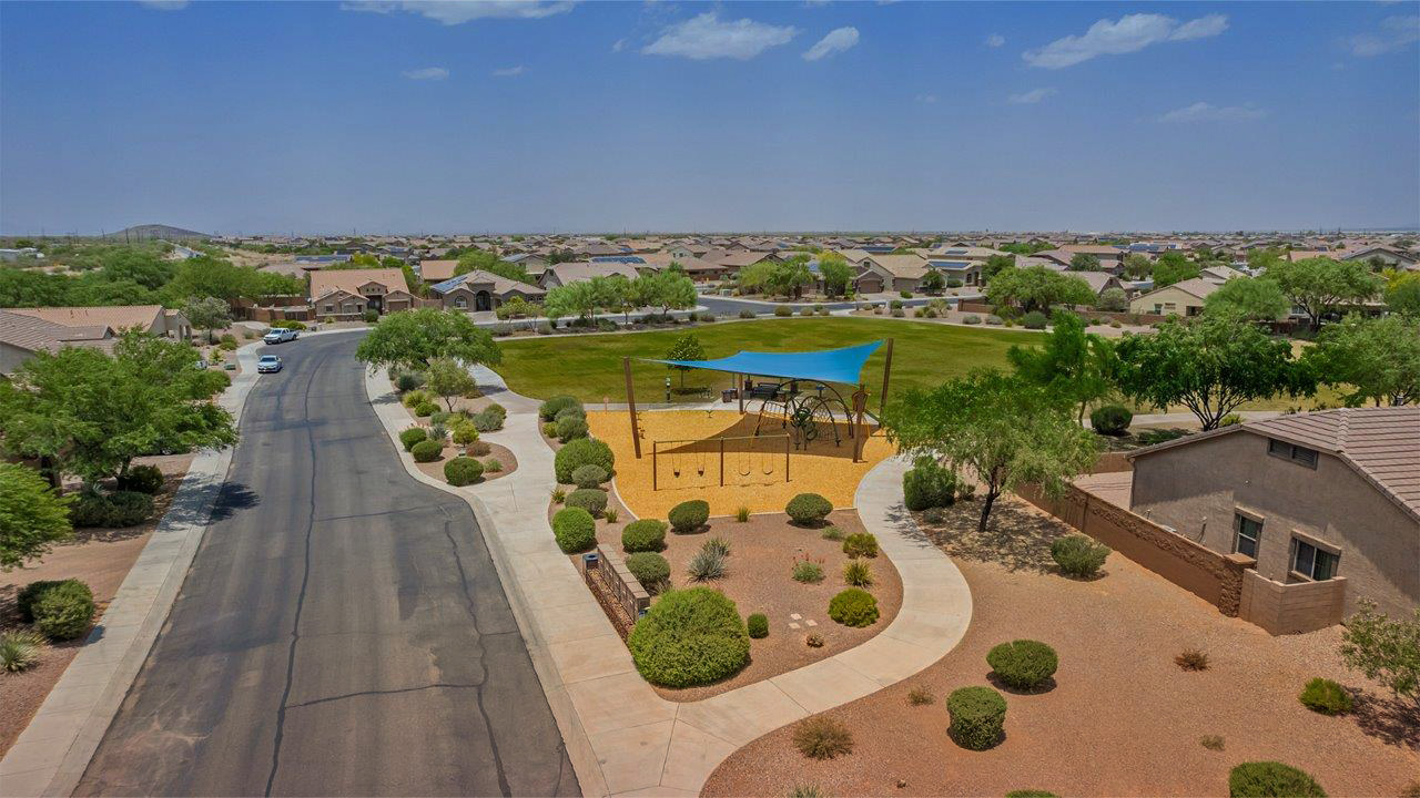 Welcome to The Pearl, a beautifully designed single-story new home located in the serene Cholla Ridge neighborhood of Saguaro Bloom. Spanning 2,431 square feet, this home offers four spacious bedrooms and three full bathrooms, making it an ideal choice for families who value both space and comfort.  As you enter through the front porch, you’re welcomed into a bright and open entryway that leads to the heart of the home. The expansive great room, dining area, and kitchen are seamlessly connected, providing a perfect setting for both everyday living and entertaining. The kitchen is a chef’s delight, featuring a large island, granite countertops, and Shaker-style cabinetry in double espresso. With a generously sized pantry and modern stainless steel gas appliances, this kitchen is both functional and stylish.  The Pearl’s layout includes a well-placed primary bedroom at the rear of the home, ensuring privacy and tranquility. The primary suite features a spacious walk-in closet and an en-suite bathroom with dual executive-height vanities and a large walk-in shower. The additional three bedrooms are located towards the front and sides of the home, each offering ample closet space and access to two full bathrooms, making this layout perfect for families and guests alike.  The outdoor living space is just as inviting, with a covered patio that extends from the great room, providing an ideal spot for enjoying Arizona’s beautiful weather. Whether you’re hosting a gathering or simply relaxing with a good book, this space is designed for your enjoyment.  The Pearl also features a dedicated utility room near the kitchen, making household tasks more convenient. A two-car garage offers plenty of space for vehicles and additional storage.  Built with energy efficiency and modern living in mind, The Pearl incorporates eco-friendly features and smart home technology, ensuring a comfortable and sustainable lifestyle. Large windows throughout the home allow natural light to flood the space, creating a warm and inviting atmosphere.  Located within the exclusive Cholla Ridge neighborhood at Saguaro Bloom, residents of The Pearl enjoy a range of amenities, including beautiful 12x24” tile flooring, and gourmet kitchens in select homes, all on lots with no rear neighbors. The community offers access to two pools, walking trails, and parks, all set against the stunning backdrop of the Tucson Mountains.  The Pearl combines style, comfort, and practicality, making it a perfect place to call home in one of Marana’s most sought-after communities.