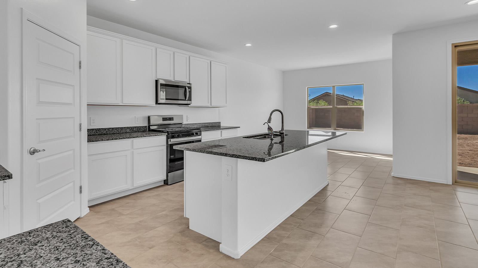 Welcome to The Pearl, a beautifully designed single-story new home located in the serene Cholla Ridge neighborhood of Saguaro Bloom. Spanning 2,431 square feet, this home offers four spacious bedrooms and three full bathrooms, making it an ideal choice for families who value both space and comfort.  As you enter through the front porch, you’re welcomed into a bright and open entryway that leads to the heart of the home. The expansive great room, dining area, and kitchen are seamlessly connected, providing a perfect setting for both everyday living and entertaining. The kitchen is a chef’s delight, featuring a large island, granite countertops, and Shaker-style cabinetry in double espresso. With a generously sized pantry and modern stainless steel gas appliances, this kitchen is both functional and stylish.  The Pearl’s layout includes a well-placed primary bedroom at the rear of the home, ensuring privacy and tranquility. The primary suite features a spacious walk-in closet and an en-suite bathroom with dual executive-height vanities and a large walk-in shower. The additional three bedrooms are located towards the front and sides of the home, each offering ample closet space and access to two full bathrooms, making this layout perfect for families and guests alike.  The outdoor living space is just as inviting, with a covered patio that extends from the great room, providing an ideal spot for enjoying Arizona’s beautiful weather. Whether you’re hosting a gathering or simply relaxing with a good book, this space is designed for your enjoyment.  The Pearl also features a dedicated utility room near the kitchen, making household tasks more convenient. A two-car garage offers plenty of space for vehicles and additional storage.  Built with energy efficiency and modern living in mind, The Pearl incorporates eco-friendly features and smart home technology, ensuring a comfortable and sustainable lifestyle. Large windows throughout the home allow natural light to flood the space, creating a warm and inviting atmosphere.  Located within the exclusive Cholla Ridge neighborhood at Saguaro Bloom, residents of The Pearl enjoy a range of amenities, including beautiful 12x24” tile flooring, and gourmet kitchens in select homes, all on lots with no rear neighbors. The community offers access to two pools, walking trails, and parks, all set against the stunning backdrop of the Tucson Mountains.  The Pearl combines style, comfort, and practicality, making it a perfect place to call home in one of Marana’s most sought-after communities.