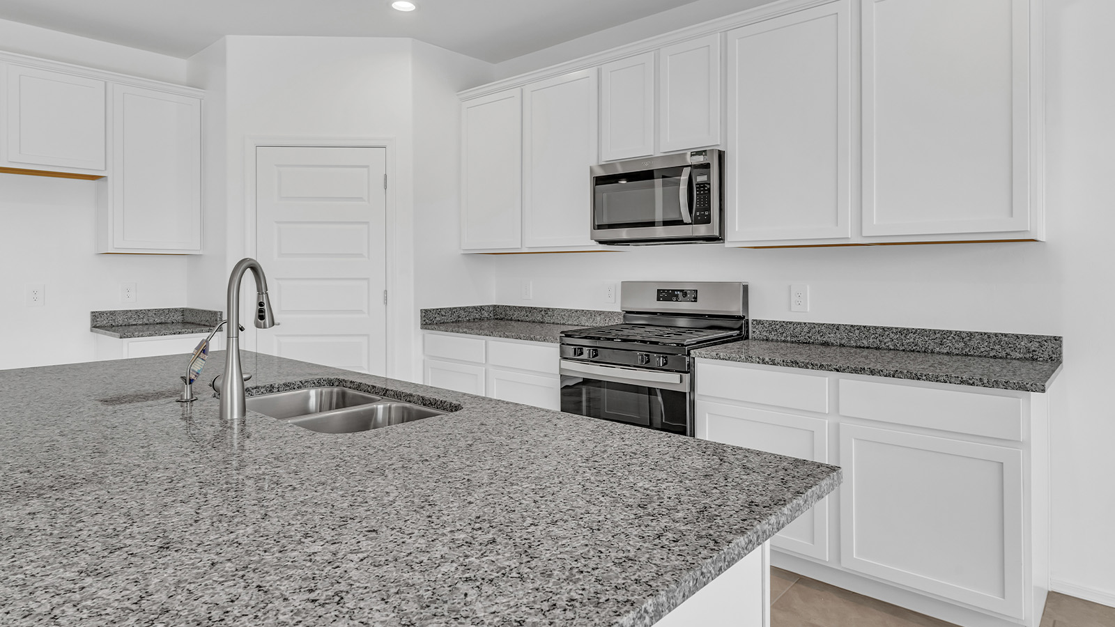 Welcome to The Pearl, a beautifully designed single-story new home located in the serene Cholla Ridge neighborhood of Saguaro Bloom. Spanning 2,431 square feet, this home offers four spacious bedrooms and three full bathrooms, making it an ideal choice for families who value both space and comfort.  As you enter through the front porch, you’re welcomed into a bright and open entryway that leads to the heart of the home. The expansive great room, dining area, and kitchen are seamlessly connected, providing a perfect setting for both everyday living and entertaining. The kitchen is a chef’s delight, featuring a large island, granite countertops, and Shaker-style cabinetry in double espresso. With a generously sized pantry and modern stainless steel gas appliances, this kitchen is both functional and stylish.  The Pearl’s layout includes a well-placed primary bedroom at the rear of the home, ensuring privacy and tranquility. The primary suite features a spacious walk-in closet and an en-suite bathroom with dual executive-height vanities and a large walk-in shower. The additional three bedrooms are located towards the front and sides of the home, each offering ample closet space and access to two full bathrooms, making this layout perfect for families and guests alike.  The outdoor living space is just as inviting, with a covered patio that extends from the great room, providing an ideal spot for enjoying Arizona’s beautiful weather. Whether you’re hosting a gathering or simply relaxing with a good book, this space is designed for your enjoyment.  The Pearl also features a dedicated utility room near the kitchen, making household tasks more convenient. A two-car garage offers plenty of space for vehicles and additional storage.  Built with energy efficiency and modern living in mind, The Pearl incorporates eco-friendly features and smart home technology, ensuring a comfortable and sustainable lifestyle. Large windows throughout the home allow natural light to flood the space, creating a warm and inviting atmosphere.  Located within the exclusive Cholla Ridge neighborhood at Saguaro Bloom, residents of The Pearl enjoy a range of amenities, including beautiful 12x24” tile flooring, and gourmet kitchens in select homes, all on lots with no rear neighbors. The community offers access to two pools, walking trails, and parks, all set against the stunning backdrop of the Tucson Mountains.  The Pearl combines style, comfort, and practicality, making it a perfect place to call home in one of Marana’s most sought-after communities.