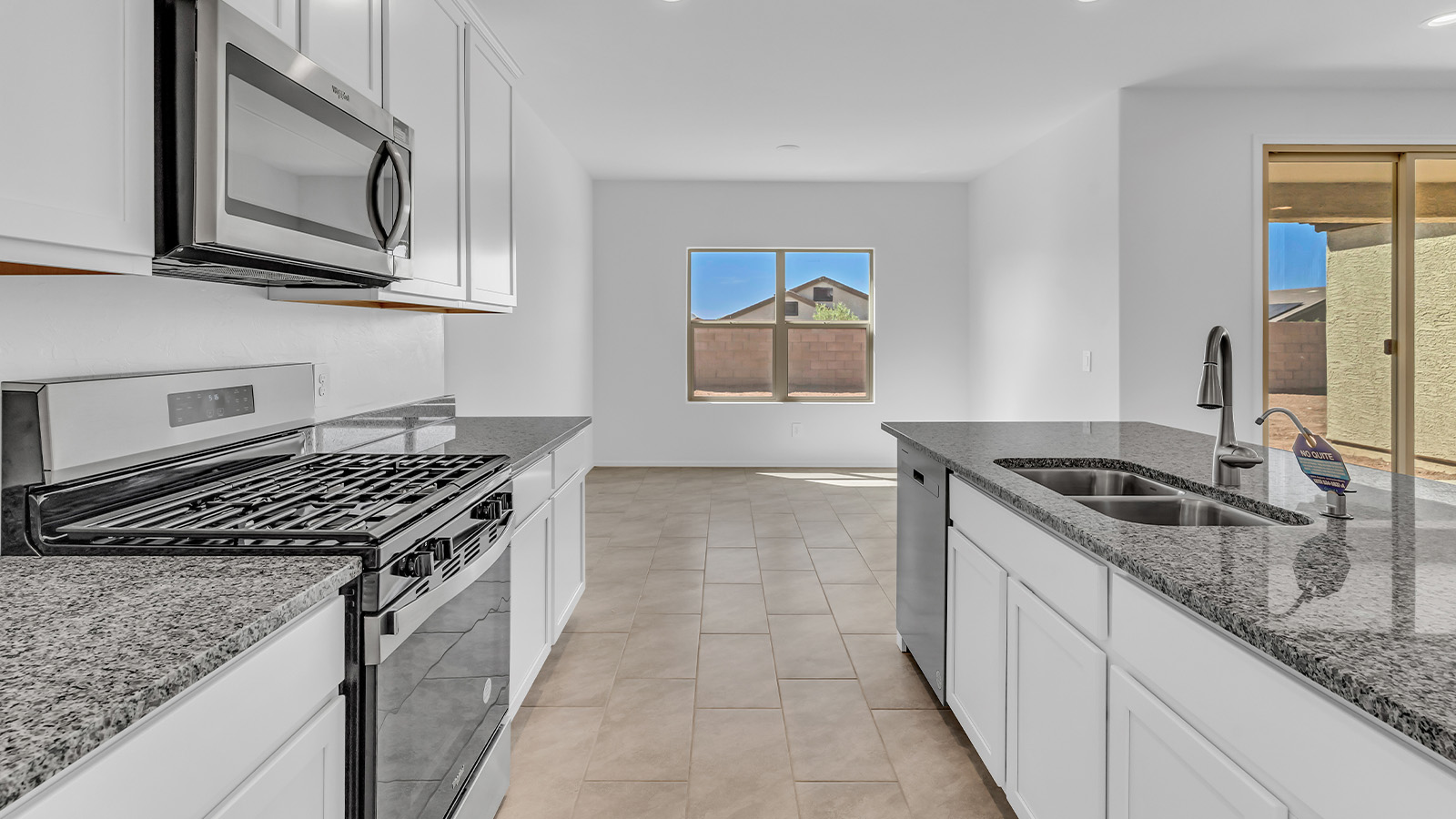 Welcome to The Pearl, a beautifully designed single-story new home located in the serene Cholla Ridge neighborhood of Saguaro Bloom. Spanning 2,431 square feet, this home offers four spacious bedrooms and three full bathrooms, making it an ideal choice for families who value both space and comfort.  As you enter through the front porch, you’re welcomed into a bright and open entryway that leads to the heart of the home. The expansive great room, dining area, and kitchen are seamlessly connected, providing a perfect setting for both everyday living and entertaining. The kitchen is a chef’s delight, featuring a large island, granite countertops, and Shaker-style cabinetry in double espresso. With a generously sized pantry and modern stainless steel gas appliances, this kitchen is both functional and stylish.  The Pearl’s layout includes a well-placed primary bedroom at the rear of the home, ensuring privacy and tranquility. The primary suite features a spacious walk-in closet and an en-suite bathroom with dual executive-height vanities and a large walk-in shower. The additional three bedrooms are located towards the front and sides of the home, each offering ample closet space and access to two full bathrooms, making this layout perfect for families and guests alike.  The outdoor living space is just as inviting, with a covered patio that extends from the great room, providing an ideal spot for enjoying Arizona’s beautiful weather. Whether you’re hosting a gathering or simply relaxing with a good book, this space is designed for your enjoyment.  The Pearl also features a dedicated utility room near the kitchen, making household tasks more convenient. A two-car garage offers plenty of space for vehicles and additional storage.  Built with energy efficiency and modern living in mind, The Pearl incorporates eco-friendly features and smart home technology, ensuring a comfortable and sustainable lifestyle. Large windows throughout the home allow natural light to flood the space, creating a warm and inviting atmosphere.  Located within the exclusive Cholla Ridge neighborhood at Saguaro Bloom, residents of The Pearl enjoy a range of amenities, including beautiful 12x24” tile flooring, and gourmet kitchens in select homes, all on lots with no rear neighbors. The community offers access to two pools, walking trails, and parks, all set against the stunning backdrop of the Tucson Mountains.  The Pearl combines style, comfort, and practicality, making it a perfect place to call home in one of Marana’s most sought-after communities.