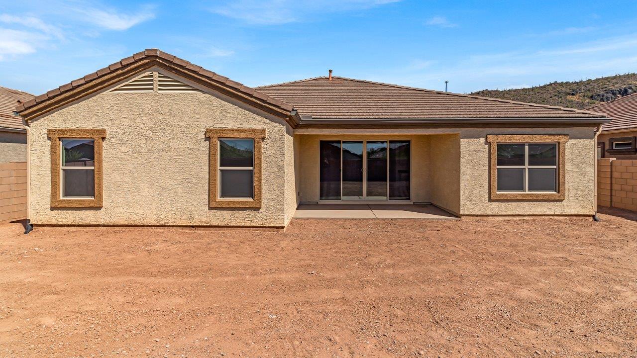 Welcome to The Pearl, a beautifully designed single-story new home located in the serene Cholla Ridge neighborhood of Saguaro Bloom. Spanning 2,431 square feet, this home offers four spacious bedrooms and three full bathrooms, making it an ideal choice for families who value both space and comfort.  As you enter through the front porch, you’re welcomed into a bright and open entryway that leads to the heart of the home. The expansive great room, dining area, and kitchen are seamlessly connected, providing a perfect setting for both everyday living and entertaining. The kitchen is a chef’s delight, featuring a large island, granite countertops, and Shaker-style cabinetry in double espresso. With a generously sized pantry and modern stainless steel gas appliances, this kitchen is both functional and stylish.  The Pearl’s layout includes a well-placed primary bedroom at the rear of the home, ensuring privacy and tranquility. The primary suite features a spacious walk-in closet and an en-suite bathroom with dual executive-height vanities and a large walk-in shower. The additional three bedrooms are located towards the front and sides of the home, each offering ample closet space and access to two full bathrooms, making this layout perfect for families and guests alike.  The outdoor living space is just as inviting, with a covered patio that extends from the great room, providing an ideal spot for enjoying Arizona’s beautiful weather. Whether you’re hosting a gathering or simply relaxing with a good book, this space is designed for your enjoyment.  The Pearl also features a dedicated utility room near the kitchen, making household tasks more convenient. A two-car garage offers plenty of space for vehicles and additional storage.  Built with energy efficiency and modern living in mind, The Pearl incorporates eco-friendly features and smart home technology, ensuring a comfortable and sustainable lifestyle. Large windows throughout the home allow natural light to flood the space, creating a warm and inviting atmosphere.  Located within the exclusive Cholla Ridge neighborhood at Saguaro Bloom, residents of The Pearl enjoy a range of amenities, including beautiful 12x24” tile flooring, and gourmet kitchens in select homes, all on lots with no rear neighbors. The community offers access to two pools, walking trails, and parks, all set against the stunning backdrop of the Tucson Mountains.  The Pearl combines style, comfort, and practicality, making it a perfect place to call home in one of Marana’s most sought-after communities.