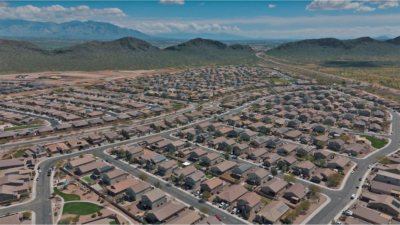 Welcome to The Pearl, a beautifully designed single-story new home located in the serene Cholla Ridge neighborhood of Saguaro Bloom. Spanning 2,431 square feet, this home offers four spacious bedrooms and three full bathrooms, making it an ideal choice for families who value both space and comfort.  As you enter through the front porch, you’re welcomed into a bright and open entryway that leads to the heart of the home. The expansive great room, dining area, and kitchen are seamlessly connected, providing a perfect setting for both everyday living and entertaining. The kitchen is a chef’s delight, featuring a large island, granite countertops, and Shaker-style cabinetry in double espresso. With a generously sized pantry and modern stainless steel gas appliances, this kitchen is both functional and stylish.  The Pearl’s layout includes a well-placed primary bedroom at the rear of the home, ensuring privacy and tranquility. The primary suite features a spacious walk-in closet and an en-suite bathroom with dual executive-height vanities and a large walk-in shower. The additional three bedrooms are located towards the front and sides of the home, each offering ample closet space and access to two full bathrooms, making this layout perfect for families and guests alike.  The outdoor living space is just as inviting, with a covered patio that extends from the great room, providing an ideal spot for enjoying Arizona’s beautiful weather. Whether you’re hosting a gathering or simply relaxing with a good book, this space is designed for your enjoyment.  The Pearl also features a dedicated utility room near the kitchen, making household tasks more convenient. A two-car garage offers plenty of space for vehicles and additional storage.  Built with energy efficiency and modern living in mind, The Pearl incorporates eco-friendly features and smart home technology, ensuring a comfortable and sustainable lifestyle. Large windows throughout the home allow natural light to flood the space, creating a warm and inviting atmosphere.  Located within the exclusive Cholla Ridge neighborhood at Saguaro Bloom, residents of The Pearl enjoy a range of amenities, including beautiful 12x24” tile flooring, and gourmet kitchens in select homes, all on lots with no rear neighbors. The community offers access to two pools, walking trails, and parks, all set against the stunning backdrop of the Tucson Mountains.  The Pearl combines style, comfort, and practicality, making it a perfect place to call home in one of Marana’s most sought-after communities.