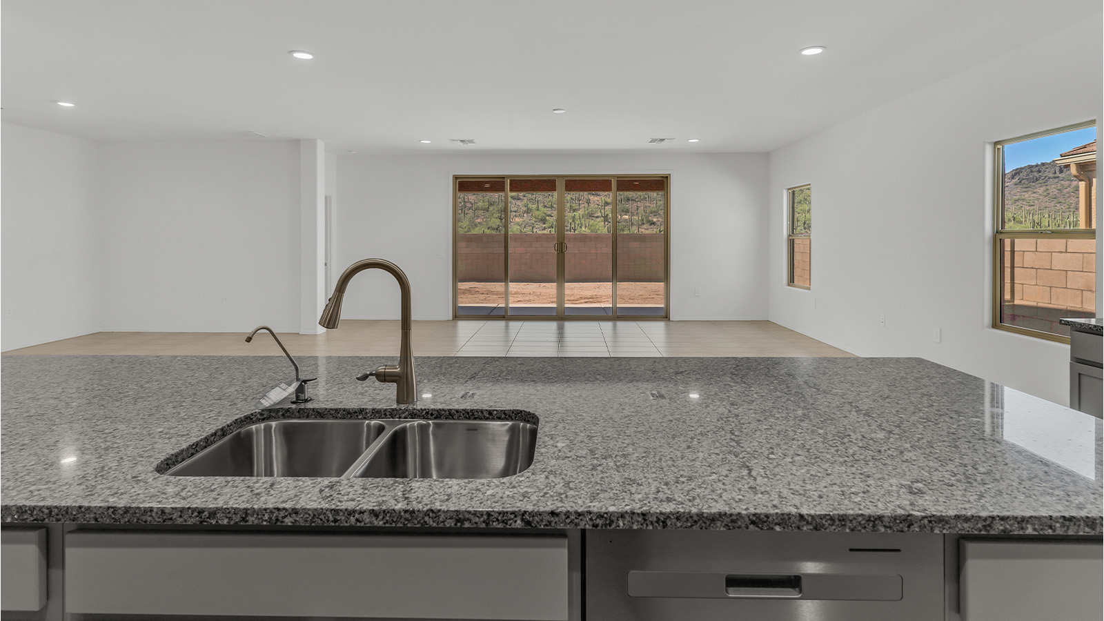 Welcome to The Citrine, a spacious single-story new home located in the tranquil Cholla Ridge neighborhood of Saguaro Bloom. With 2,577 square feet of well-planned living space, this home offers four bedrooms, three bathrooms, and a dedicated study, making it ideal for families who value both space and convenience.  As you enter through the inviting covered porch, you’re greeted by a bright and airy entryway that flows into the heart of the home. The expansive great room, dining area, and kitchen are thoughtfully connected, creating an ideal space for entertaining or simply enjoying time with family. The kitchen is a chef's dream, featuring a large island, granite countertops, and Shaker-style cabinetry in double espresso. A spacious pantry and modern stainless steel gas appliances ensure that this kitchen is both functional and stylish.  The Citrine’s layout includes a generously sized primary bedroom, carefully positioned for privacy at the rear of the home. This room features a large walk-in closet and an en-suite bathroom with dual executive-height vanities and a luxurious super shower. The additional three bedrooms are well-sized and located in separate areas of the home, ensuring privacy and easy access to two more full bathrooms.  One of the highlights of The Citrine is its versatile study, which can be used as a home office, library, media room, or extra bedroom depending on your needs. The large laundry room, conveniently situated near the bedrooms, adds to the home’s practicality.  The covered patio, accessible from the great room, offers a perfect spot for outdoor living, where you can enjoy Arizona’s beautiful weather throughout the year. Whether you’re hosting a barbecue or simply relaxing, this outdoor space enhances the home’s appeal.  Designed with energy efficiency and modern living in mind, The Citrine includes eco-friendly features and smart home technology, ensuring comfort and sustainability. Large windows throughout the home allow natural light to brighten every corner, creating a warm and welcoming atmosphere.  Located within the exclusive Cholla Ridge neighborhood at Saguaro Bloom, residents of The Citrine enjoy a range of premium features, including beautiful 12x24” tile flooring, gourmet kitchens, and 10’ ceilings in select homes. The community offers access to two pools, walking trails, parks, and more, all set against the picturesque backdrop of the Tucson Mountains.  The Citrine combines style, comfort, and practicality, making it a perfect place to call home in one of Marana’s most sought-after communities.