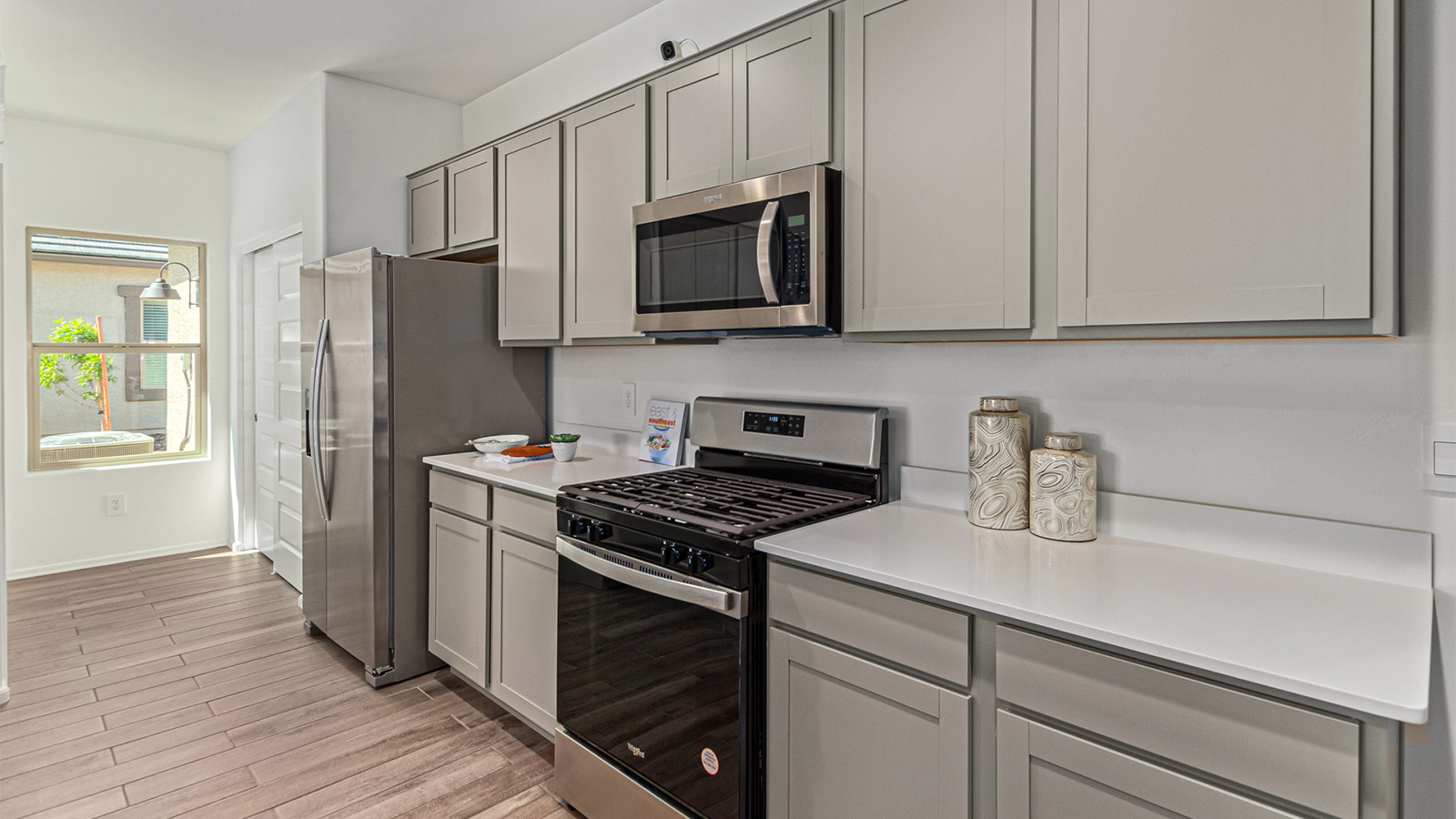 Welcome to the Kingston floor plan in the Agave neighborhood at Saguaro Bloom, Marana, Arizona—a perfect blend of comfort, modern living, and energy efficiency. This thoughtfully crafted one-story home spans 2,051 square feet and offers four bedrooms and two bathrooms, ideal for families of all sizes.  The open-concept design features a spacious great room that effortlessly connects with the kitchen and dining area, creating an inviting central hub for everyday living and entertaining. The kitchen is equipped with contemporary appliances and a pantry.  The primary bedroom, located at the rear of the home, provides a peaceful retreat with a private ensuite bathroom and a walk-in closet. The additional three bedrooms are positioned at the front of the house, offering versatility for use as guest rooms, a home office, or children’s bedrooms. Step outside to the covered patio, a perfect spot to enjoy the beautiful Arizona weather.  Built with energy efficiency as a priority, the Kingston includes smart home technology, which not only simplifies daily living but also helps reduce utility costs. A two-car garage provides ample parking and additional storage space, enhancing the home’s functionality.  Residents of Saguaro Bloom enjoy access to a range of community amenities, including parks, walking trails, and recreational facilities, making this home an ideal choice for those seeking a balanced lifestyle in a scenic setting.