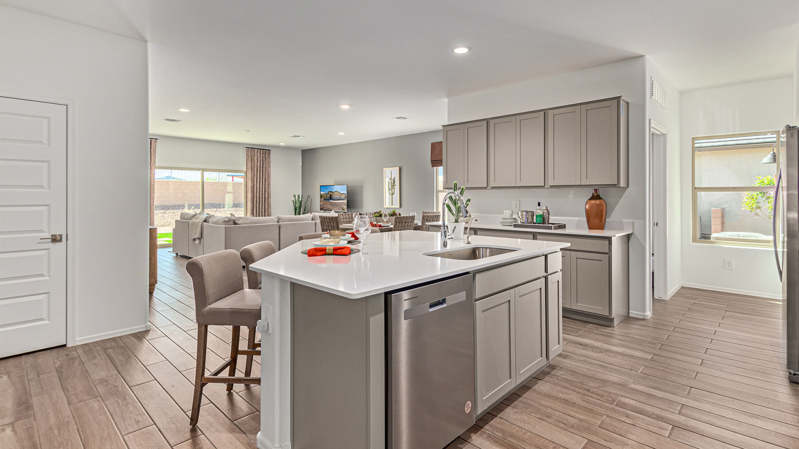 Welcome to the Kingston floor plan in the Agave neighborhood at Saguaro Bloom, Marana, Arizona—a perfect blend of comfort, modern living, and energy efficiency. This thoughtfully crafted one-story home spans 2,051 square feet and offers four bedrooms and two bathrooms, ideal for families of all sizes.  The open-concept design features a spacious great room that effortlessly connects with the kitchen and dining area, creating an inviting central hub for everyday living and entertaining. The kitchen is equipped with contemporary appliances and a pantry.  The primary bedroom, located at the rear of the home, provides a peaceful retreat with a private ensuite bathroom and a walk-in closet. The additional three bedrooms are positioned at the front of the house, offering versatility for use as guest rooms, a home office, or children’s bedrooms. Step outside to the covered patio, a perfect spot to enjoy the beautiful Arizona weather.  Built with energy efficiency as a priority, the Kingston includes smart home technology, which not only simplifies daily living but also helps reduce utility costs. A two-car garage provides ample parking and additional storage space, enhancing the home’s functionality.  Residents of Saguaro Bloom enjoy access to a range of community amenities, including parks, walking trails, and recreational facilities, making this home an ideal choice for those seeking a balanced lifestyle in a scenic setting.