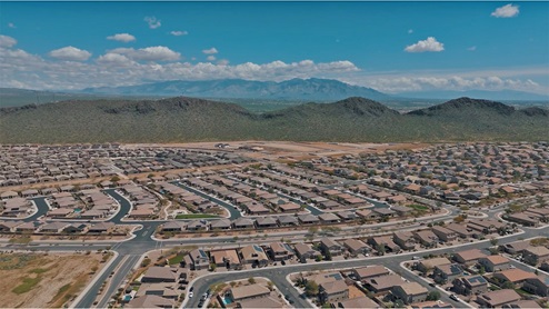 Explore New Homes at Saguaro Bloom by D.R. Horton – A Master-Planned Community in Marana, AZ. Nestled in the foothills of the breathtaking Tucson Mountains, Saguaro Bloom by D.R. Horton is a premier master-planned community in Northwest Marana that offers an exceptional living experience. Saguaro Bloom is divided into distinct neighborhoods, each offering its unique charm and amenities. *Mesquite at Saguaro Bloom* is located in Block 1 and offers a variety of spacious floorplans with 18x18 tile flooring, granite countertops in kitchen and bathrooms, and Shaker-style cabinets in white or gray. These homes feature 9’ ceilings on the first floor, island kitchens, and the Home is Connected® Smart Home package, making them perfect for modern living. *Agave at Saguaro Bloom*, situated in Block 7C, features homes with stunning 6x36” wood-look tile in gray, quartz countertops in kitchen and bathrooms, and Shaker-style cabinets. These homes are designed with stylish interiors and modern conveniences, including LED disc lighting and energy-efficient tankless water heaters. *Cholla Ridge at Saguaro Bloom*, located in Block 7B, offers single-story homes on lots with no rear neighbors. These homes are distinguished by beautiful 12x24” tile flooring, gourmet kitchens, and 10’ ceilings in select homes. With 8’ sliding glass patio doors and super showers, Cholla Ridge combines luxury and privacy in a serene setting. All homes in Saguaro Bloom are built with a Spanish lace stucco exterior, tile roofs, landscaped front yards with auto drip irrigation, and large, fully fenced backyards ready for your design. The homes also include covered front porches and back patios, stainless steel gas appliances, and executive height vanities in all bathrooms. Additionally, as of August 2024, all homes starting production are Zero Energy Ready, meeting rigorous energy efficiency standards that significantly reduce energy costs and environmental impact. Residents of Saguaro Bloom enjoy an array of community amenities, including a clubhouse, two pools with lap lanes and lagoon entry, a fitness center, a splash pad, and over 30 miles of walking trails. The community also features more than 20 pocket parks, playgrounds, and coming soon, a large community park with tennis, pickleball, soccer, baseball, and a dog park. Saguaro Bloom is truly a lifestyle community, offering regular events like Food Truck Thursdays, Movies at the Pool, and holiday decorating contests, all fostering a strong sense of community. Located in the highly-rated Marana Unified School District, Saguaro Bloom is close to excellent schools, including Rattlesnake Ridge Elementary, Marana Middle School, and Marana High School. The community’s location offers a perfect balance of seclusion and convenience, with quick access to I-10, grocery stores, restaurants, and the Twin Peaks Outlet, all within minutes. Downtown Tucson, with its vibrant arts, culture, and entertainment scene, is just a short 15-minute drive away. Surrounded by the natural beauty of the desert landscape, residents can explore nearby outdoor attractions like Saguaro National Park West, the Arizona Desert Museum, and Quarry Pines Golf Course. Whether you enjoy hiking, biking, or simply taking in the stunning views, Saguaro Bloom offers an unparalleled lifestyle in one of Arizona’s most sought-after locations. Discover the perfect blend of modern amenities, scenic beauty, and a strong sense of community at Saguaro Bloom by D.R. Horton – where your new home awaits in Marana, AZ.