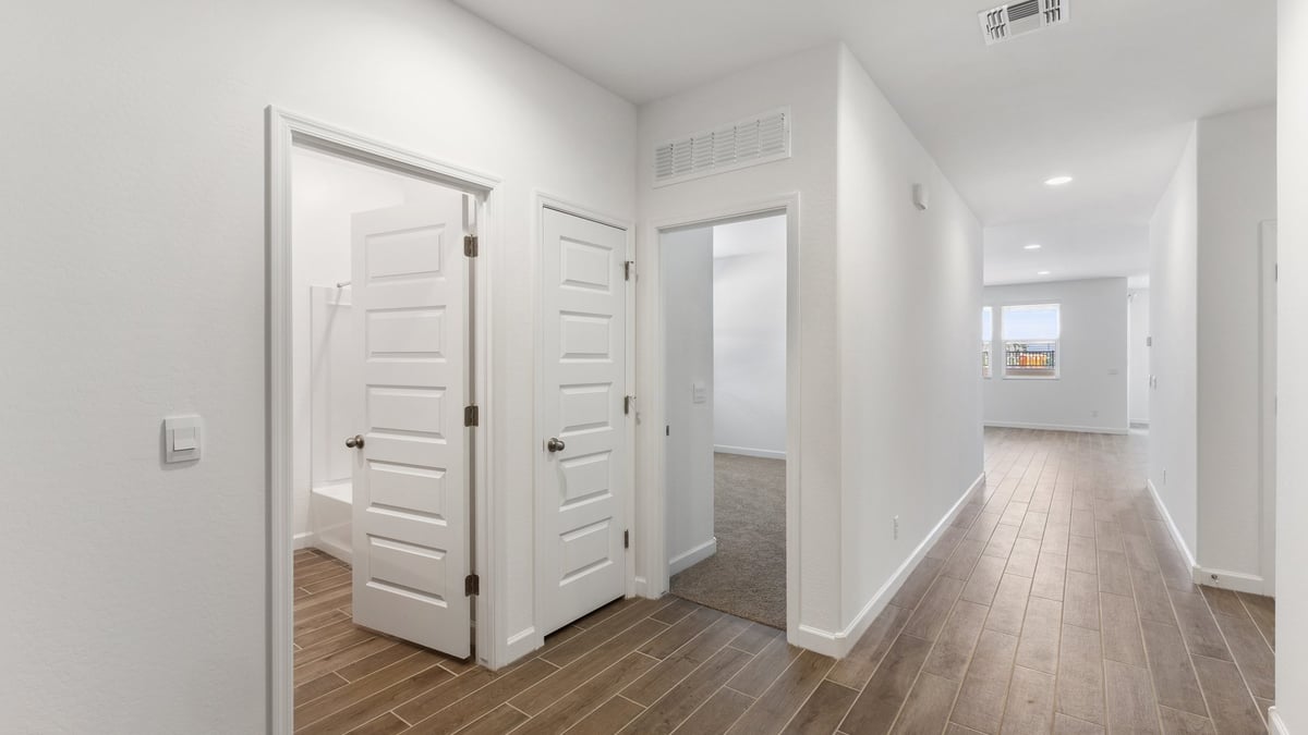 The Garland floor plan is a spacious single-story new home situated in the Agave neighborhood at Saguaro Bloom, offering 2,273 square feet of well-planned living space that perfectly suits a variety of lifestyles. This home features four bedrooms and three full bathrooms making it an ideal choice for families and those needing room to grow. As you step into the front porch and through the front door, you're greeted by the open concept layout with a seamless flow between the living, dining, and kitchen area, ensuring that every part of the home feels connected. The kitchen, equipped with a central island, quartz countertops, and your choice of flat panel Shaker-style cabinet doors with multiple color options available. A walk-in pantry provides additional storage, making it easy to keep everything organized.  The Garland's four bedrooms are thoughtfully arranged to provide both privacy and convenience. The primary suite is tucked away at the rear of the home, offering a private retreat with walk-in closets off the en-suite bathroom complete with an optional dual sink vanity. The additional bedrooms are strategically placed near the front and center of the home, each with access to a full bathroom, ensuring comfort for all family members or guests.  The large great room serves as the central gathering space, perfect for family activities or entertaining guests. Adjacent to the great room is a covered patio, extending your living space outdoors and offering a perfect spot to enjoy the serene surroundings of Saguaro Bloom.  Practical features like a dedicated utility room and a spacious three-car garage enhance the functionality of this home, while large windows ensure that natural light fills the space, creating a bright and inviting atmosphere.  Located within the vibrant Saguaro Bloom community, residents of The Garland can take advantage of a wide array of amenities, from resort-style pools to extensive walking trails. This home offers a unique opportunity to enjoy both comfort and community in one of Marana’s most sought-after neighborhoods.