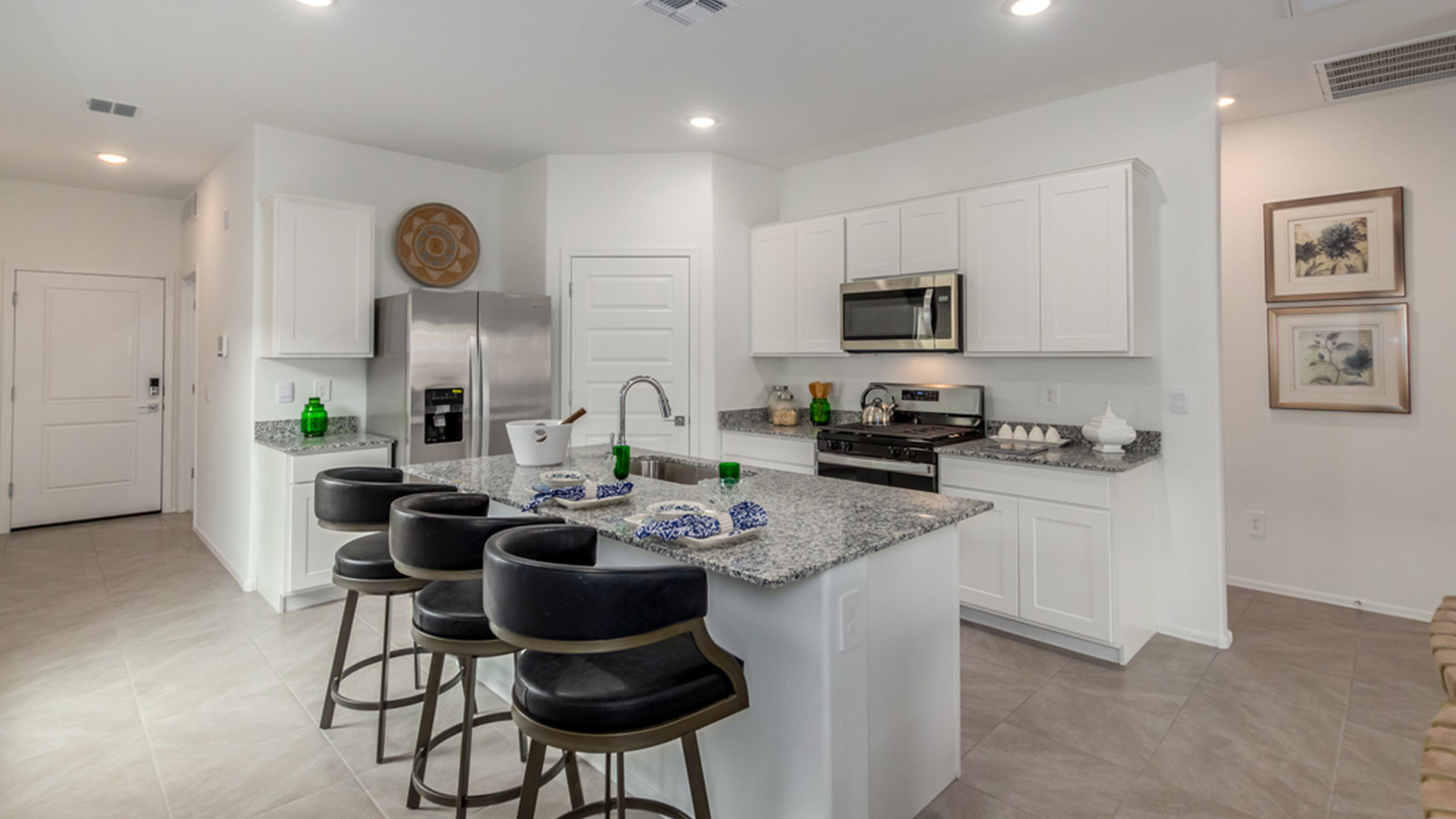 Welcome to The Amber, a thoughtfully designed single-story new home nestled in the Mesquite neighborhood at Saguaro Bloom, a master-planned community in Marana, Arizona. With 1,331 square feet of efficient living space, The Amber is perfect for those seeking a cozy yet functional home.  *Images shown are for reference only. They depict the Amber model home and may not represent the actual home. Step into a welcoming entryway that immediately introduces you to the home’s smart layout. The open design maximizes every square foot, with the heart of the home being the expansive great room, which flows seamlessly into the dining area and kitchen. The kitchen is well-equipped with a central island, granite countertops, and Shaker-style cabinets in either white or gray, offering a clean and modern aesthetic. A dedicated walk-in pantry adds extra storage, ensuring that all your culinary essentials are within reach.  The Amber offers three comfortable bedrooms, providing ample space for rest and relaxation. The primary suite is situated at the rear of the home, providing a sense of privacy. It includes a walk-in closet and an en-suite bathroom that features all the essentials for convenience. The two additional bedrooms are thoughtfully placed near the front of the home, sharing access to a full bathroom, making this layout perfect for families, guests, or a home office.  Practicality meets comfort in this home, with a utility room conveniently located near the kitchen and garage, providing easy access to the laundry area and additional storage. The Amber also includes a covered patio that extends the living space outdoors, ideal for enjoying Arizona’s beautiful weather.  The Amber is located in the vibrant Saguaro Bloom community, residents enjoy access to a wide range of amenities, from swimming pools and parks to miles of scenic walking trails. Whether you’re a first-time homebuyer or looking to downsize, The Amber offers a perfect blend of comfort, style, and convenience in one of Marana’s most desirable neighborhoods.