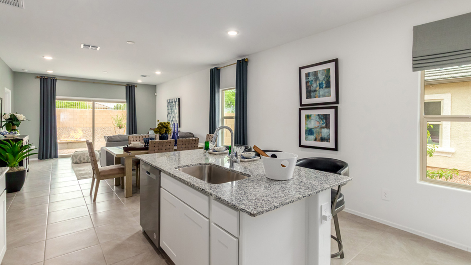 Welcome to The Amber, a thoughtfully designed single-story new home nestled in the Mesquite neighborhood at Saguaro Bloom, a master-planned community in Marana, Arizona. With 1,331 square feet of efficient living space, The Amber is perfect for those seeking a cozy yet functional home.  Step into a welcoming entryway that immediately introduces you to the home’s smart layout. The open design maximizes every square foot, with the heart of the home being the expansive great room, which flows seamlessly into the dining area and kitchen. The kitchen is well-equipped with a central island, granite countertops, and Shaker-style cabinets in either white or gray, offering a clean and modern aesthetic. A dedicated walk-in pantry adds extra storage, ensuring that all your culinary essentials are within reach.  The Amber offers three comfortable bedrooms, providing ample space for rest and relaxation. The primary suite is situated at the rear of the home, providing a sense of privacy. It includes a walk-in closet and an en-suite bathroom that features all the essentials for convenience. The two additional bedrooms are thoughtfully placed near the front of the home, sharing access to a full bathroom, making this layout perfect for families, guests, or a home office.  Practicality meets comfort in this home, with a utility room conveniently located near the kitchen and garage, providing easy access to the laundry area and additional storage. The Amber also includes a covered patio that extends the living space outdoors, ideal for enjoying Arizona’s beautiful weather.  The Amber is located in the vibrant Saguaro Bloom community, residents enjoy access to a wide range of amenities, from swimming pools and parks to miles of scenic walking trails. Whether you’re a first-time homebuyer or looking to downsize, The Amber offers a perfect blend of comfort, style, and convenience in one of Marana’s most desirable neighborhoods.  *Images shown are for reference only. They depict the Amber Model home and may not represent the actual home.