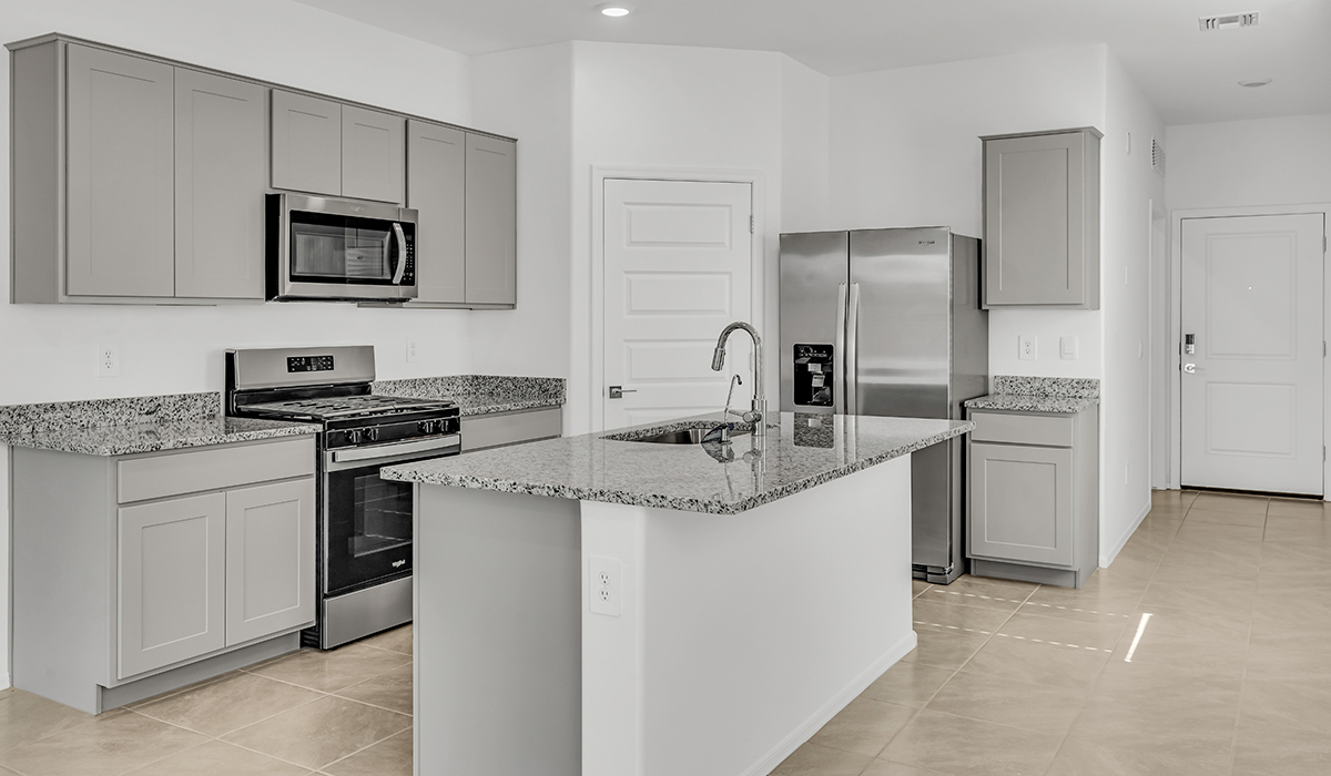 Welcome to The Amber, a thoughtfully designed single-story new home nestled in the Mesquite neighborhood at Saguaro Bloom, a master-planned community in Marana, Arizona. With 1,331 square feet of efficient living space, The Amber is perfect for those seeking a cozy yet functional home.  Step into a welcoming entryway that immediately introduces you to the home’s smart layout. The open design maximizes every square foot, with the heart of the home being the expansive great room, which flows seamlessly into the dining area and kitchen. The kitchen is well-equipped with a central island, granite countertops, and Shaker-style cabinets in either white or gray, offering a clean and modern aesthetic. A dedicated walk-in pantry adds extra storage, ensuring that all your culinary essentials are within reach.  The Amber offers three comfortable bedrooms, providing ample space for rest and relaxation. The primary suite is situated at the rear of the home, providing a sense of privacy. It includes a walk-in closet and an en-suite bathroom that features all the essentials for convenience. The two additional bedrooms are thoughtfully placed near the front of the home, sharing access to a full bathroom, making this layout perfect for families, guests, or a home office.  Practicality meets comfort in this home, with a utility room conveniently located near the kitchen and garage, providing easy access to the laundry area and additional storage. The Amber also includes a covered patio that extends the living space outdoors, ideal for enjoying Arizona’s beautiful weather.  The Amber is located in the vibrant Saguaro Bloom community, residents enjoy access to a wide range of amenities, from swimming pools and parks to miles of scenic walking trails. Whether you’re a first-time homebuyer or looking to downsize, The Amber offers a perfect blend of comfort, style, and convenience in one of Marana’s most desirable neighborhoods.  *Images shown are for reference only. They depict the Amber model home and may not represent the actual home.