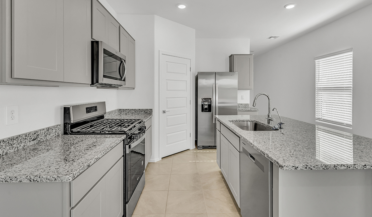 Welcome to The Amber, a thoughtfully designed single-story new home nestled in the Mesquite neighborhood at Saguaro Bloom, a master-planned community in Marana, Arizona. With 1,331 square feet of efficient living space, The Amber is perfect for those seeking a cozy yet functional home.  Step into a welcoming entryway that immediately introduces you to the home’s smart layout. The open design maximizes every square foot, with the heart of the home being the expansive great room, which flows seamlessly into the dining area and kitchen. The kitchen is well-equipped with a central island, granite countertops, and Shaker-style cabinets in either white or gray, offering a clean and modern aesthetic. A dedicated walk-in pantry adds extra storage, ensuring that all your culinary essentials are within reach.  The Amber offers three comfortable bedrooms, providing ample space for rest and relaxation. The primary suite is situated at the rear of the home, providing a sense of privacy. It includes a walk-in closet and an en-suite bathroom that features all the essentials for convenience. The two additional bedrooms are thoughtfully placed near the front of the home, sharing access to a full bathroom, making this layout perfect for families, guests, or a home office.  Practicality meets comfort in this home, with a utility room conveniently located near the kitchen and garage, providing easy access to the laundry area and additional storage. The Amber also includes a covered patio that extends the living space outdoors, ideal for enjoying Arizona’s beautiful weather.  The Amber is located in the vibrant Saguaro Bloom community, residents enjoy access to a wide range of amenities, from swimming pools and parks to miles of scenic walking trails. Whether you’re a first-time homebuyer or looking to downsize, The Amber offers a perfect blend of comfort, style, and convenience in one of Marana’s most desirable neighborhoods.  *Images shown are for reference only. They depict the Amber model home and may not represent the actual home.