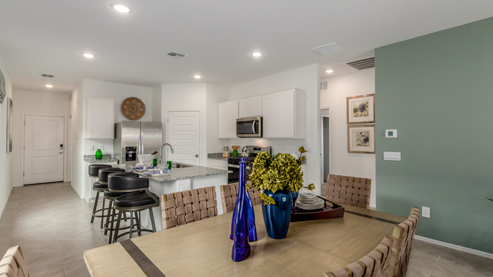 Welcome to The Amber, a thoughtfully designed single-story new home nestled in the Mesquite neighborhood at Saguaro Bloom, a master-planned community in Marana, Arizona. With 1,331 square feet of efficient living space, The Amber is perfect for those seeking a cozy yet functional home.  Step into a welcoming entryway that immediately introduces you to the home’s smart layout. The open design maximizes every square foot, with the heart of the home being the expansive great room, which flows seamlessly into the dining area and kitchen. The kitchen is well-equipped with a central island, granite countertops, and Shaker-style cabinets in either white or gray, offering a clean and modern aesthetic. A dedicated walk-in pantry adds extra storage, ensuring that all your culinary essentials are within reach.  The Amber offers three comfortable bedrooms, providing ample space for rest and relaxation. The primary suite is situated at the rear of the home, providing a sense of privacy. It includes a walk-in closet and an en-suite bathroom that features all the essentials for convenience. The two additional bedrooms are thoughtfully placed near the front of the home, sharing access to a full bathroom, making this layout perfect for families, guests, or a home office.  Practicality meets comfort in this home, with a utility room conveniently located near the kitchen and garage, providing easy access to the laundry area and additional storage. The Amber also includes a covered patio that extends the living space outdoors, ideal for enjoying Arizona’s beautiful weather.  The Amber is not just a home; it’s a lifestyle. Located in the vibrant Saguaro Bloom community, residents enjoy access to a wide range of amenities, from swimming pools and parks to miles of scenic walking trails. Whether you’re a first-time homebuyer or looking to downsize, The Amber offers a perfect blend of comfort, style, and convenience in one of Marana’s most desirable neighborhoods.