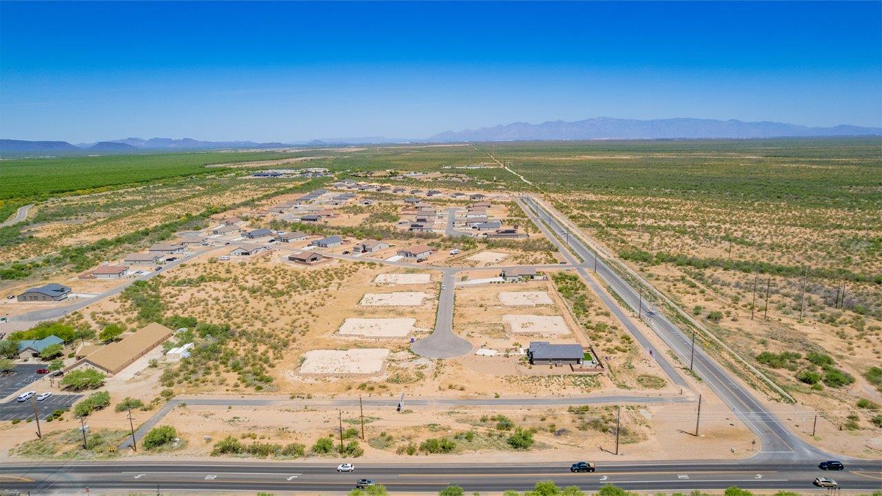 Welcome to The Madera, a beautifully expansive single-story new home nestled in the peaceful Sahuarita Acres community. With 2,131 square feet of thoughtfully arranged living space, this residence offers five bedrooms and three bathrooms, making it an exceptional choice for those who seek both comfort and versatility.  The journey through The Madera begins as you step onto the inviting front porch and enter through the welcoming foyer. The open layout immediately draws you into the spacious great room, where large windows allow natural light to fill the space, creating a warm and inviting atmosphere. The adjacent dining area flows seamlessly into the kitchen, which features a central island, quartz countertops, and 42” upper cabinets for ample storage. A walk-in pantry ensures that the kitchen remains both functional and stylish.  The Madera’s floor plan is designed with privacy in mind. The primary bedroom, located in a separate wing of the home, offers a large walk-in closet and an en-suite bathroom with dual sinks and a luxurious shower. On the opposite side of the home, four additional bedrooms are well-positioned to offer both privacy and easy access to the other two bathrooms, making this layout perfect for families or hosting guests.  One of the standout features of The Madera is its adaptability. The three-car garage and expansive near one-acre lots provide plenty of room for parking, storage, and outdoor activities, whether you envision creating a lush garden, installing a pool, or simply enjoying the vast open space.  For those who value modern conveniences, The Madera is equipped with D.R. Horton’s Home is Connected® Smart Home package, which includes a smart thermostat, video doorbell, keyless entry, a Wi-Fi-enabled garage door opener and more. Additionally, the home is built with energy efficiency in mind, featuring spray foam insulation and meeting DOE Zero Energy Ready Home standards, ensuring long-term savings and environmental benefits.  Located within the serene and spacious Sahuarita Acres community, residents of The Madera enjoy the perfect blend of small-town charm and modern amenities. With easy access to urban conveniences, excellent schools, and outdoor recreation opportunities, The Madera offers a lifestyle that embraces the essence of Arizona living.